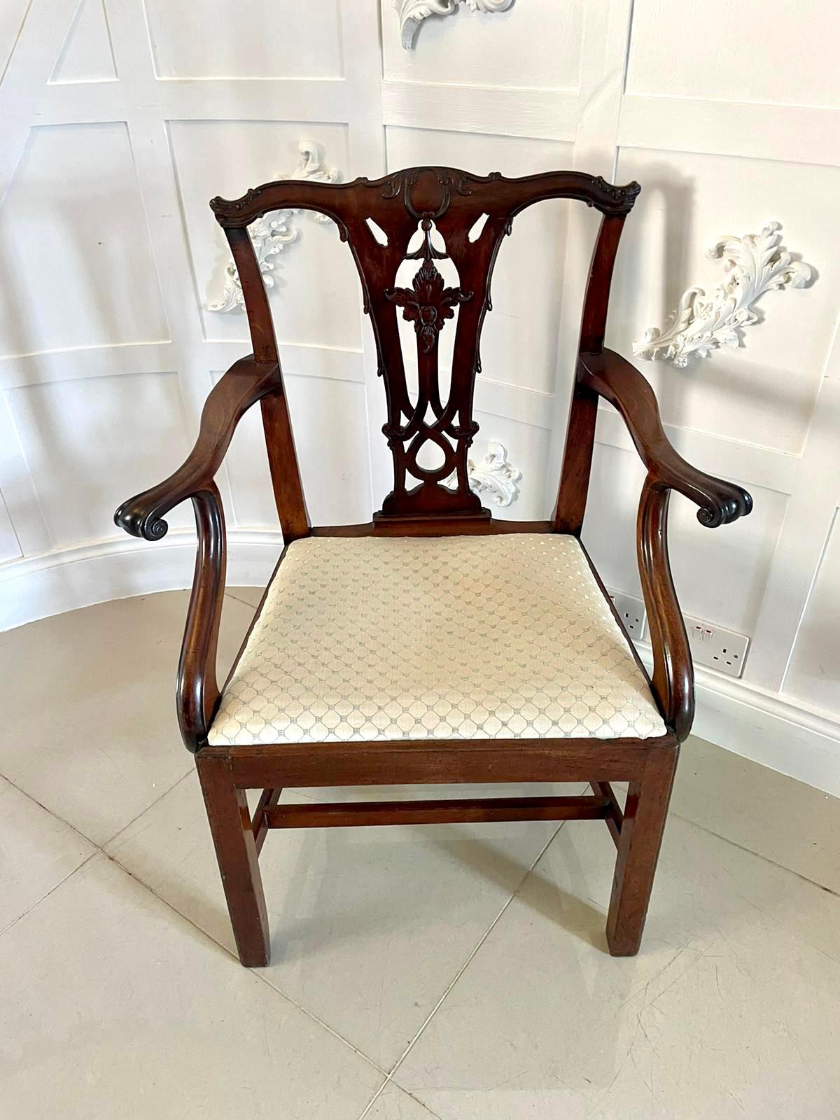 Antique George III carved mahogany elbow/desk chair having a wonderful shaped carved top and rail with open lattice work splat and shaped open arms, newly reupholstered drop in seat. It stands on elegant square moulded legs to the front and out