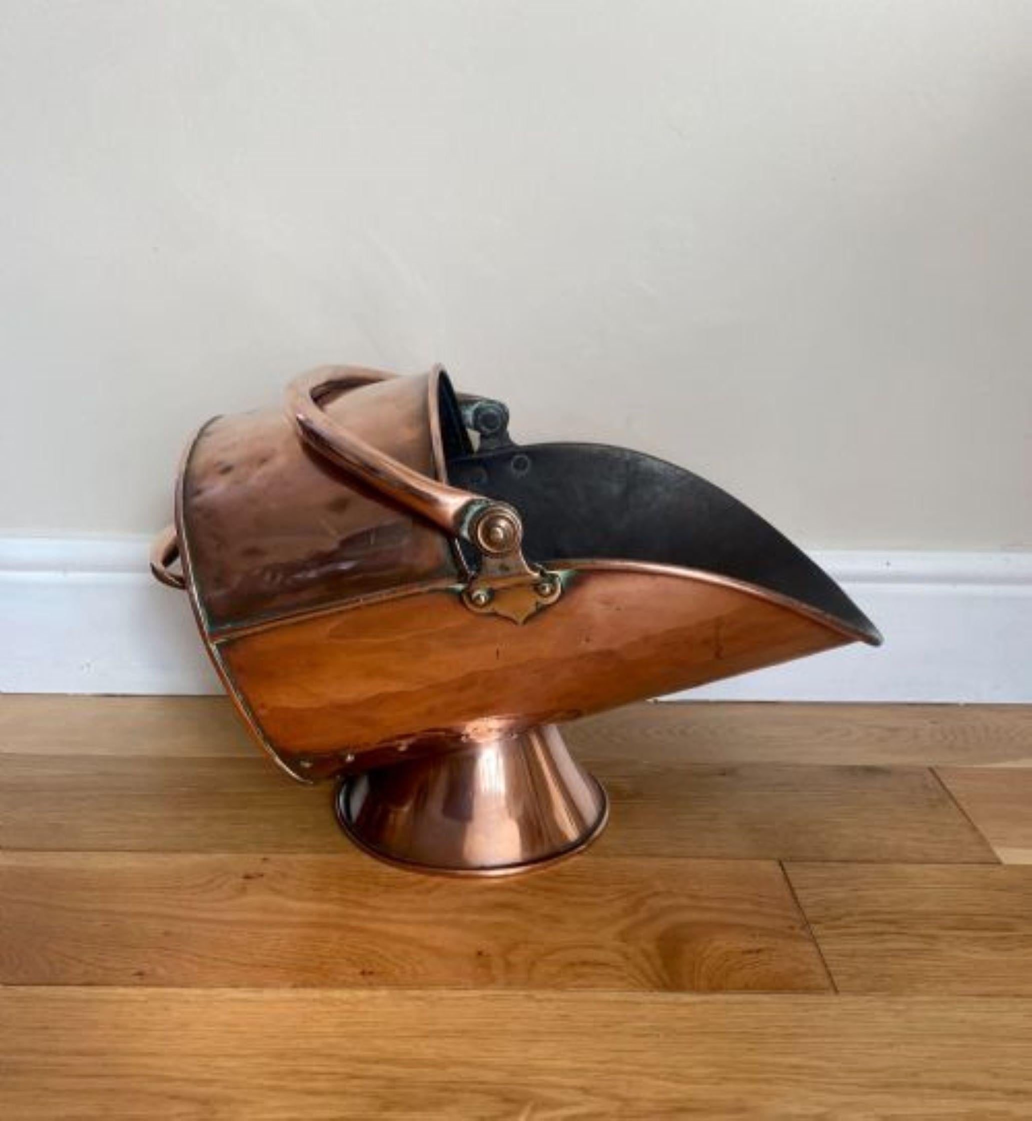 Antique George III copper helmet coal scuttle having a quality helmet coal scuttle with a swing handle, carrying handle a lovely shaped scuttle raised on a circular base.