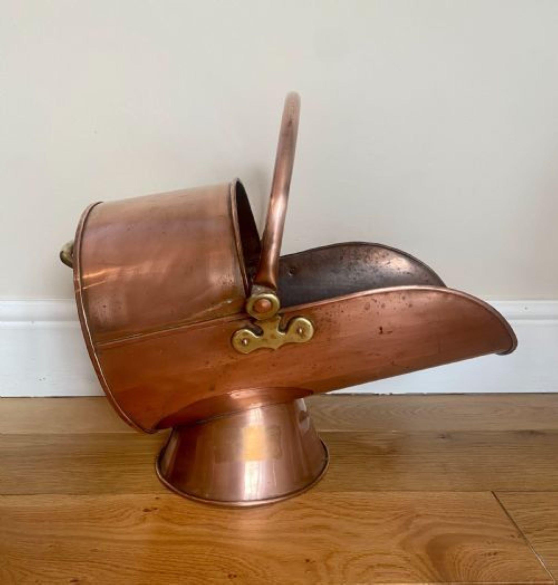 Antique George III copper helmet coal scuttle having a quality helmet coal scuttle with a swing handle, carrying handle a lovely shaped scuttle raised on a circular base.