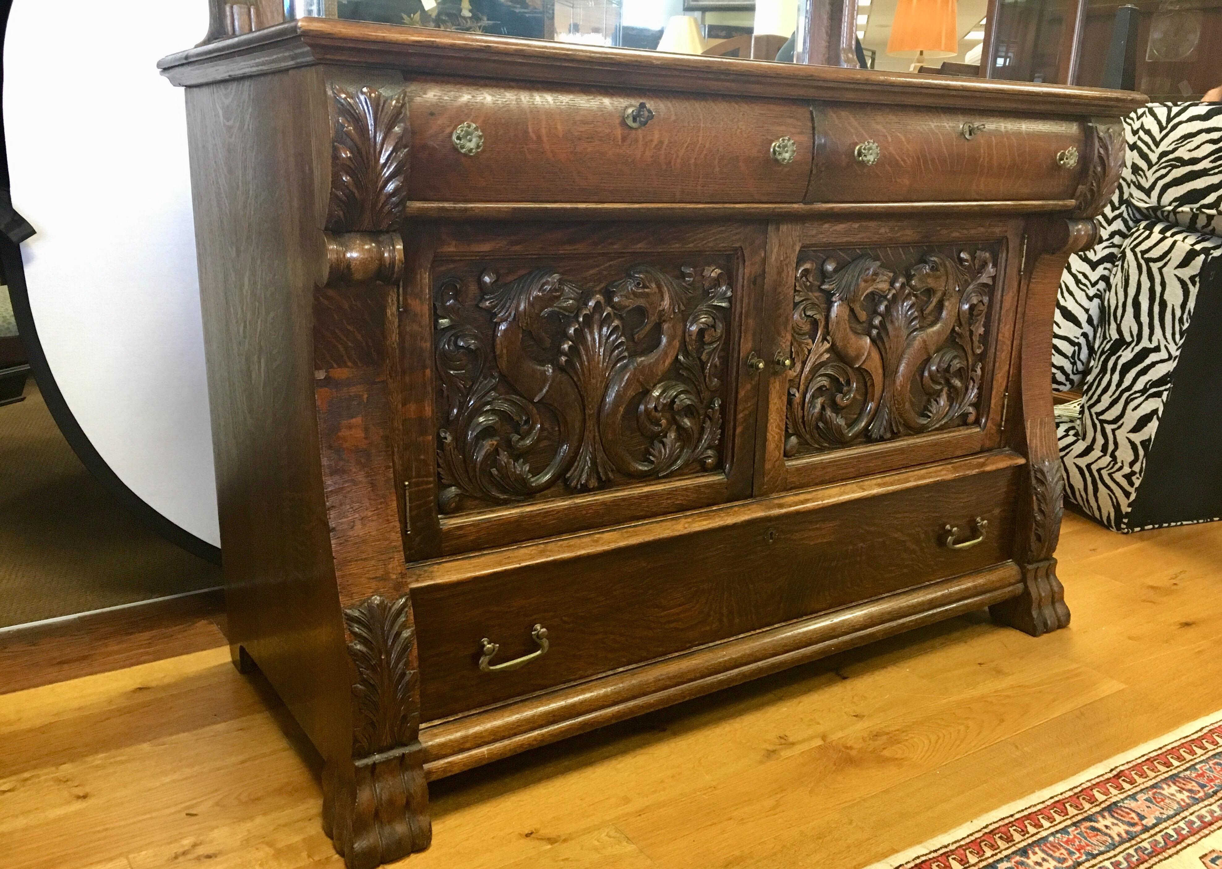 Rare and unusual carvings adorn this 19th century English George III cabinet. Features include lockable drawers and keys. The carvings on the front are magnificent.