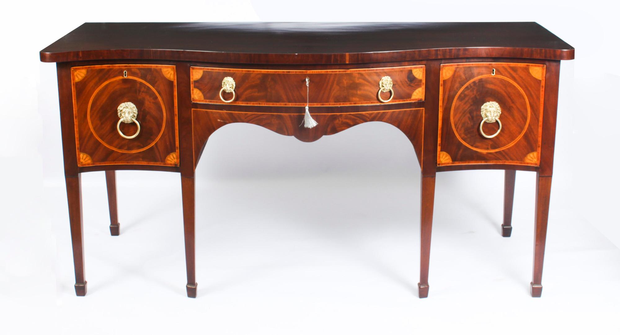 This is a superb antique George III inlaid flame mahogany serpentine sideboard, circa 1790 in date.
 
With wood banding and marquetry spandrels, the central frieze drawer flanked by deep drawers, the right side drawer with divisions for bottles. The