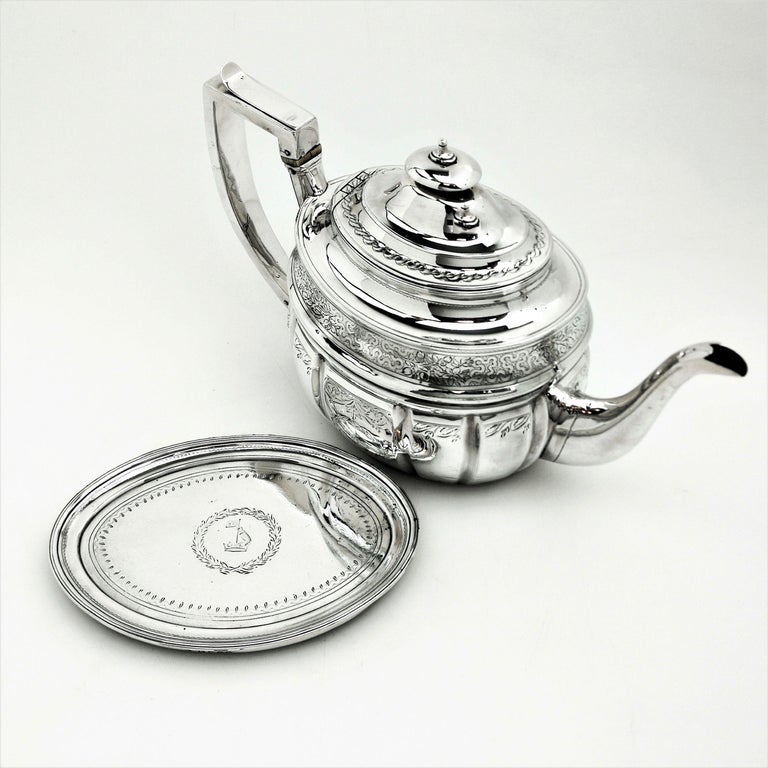 An antique George III solid Silver Teapot on Stand decorated with a pretty engraved design on the Teapot and on the Oval Tray below. The Teapot and Tray both have matched crests engraved.
 
 Made in London in 1804 by Crespin Fuller.
 
 Approx.