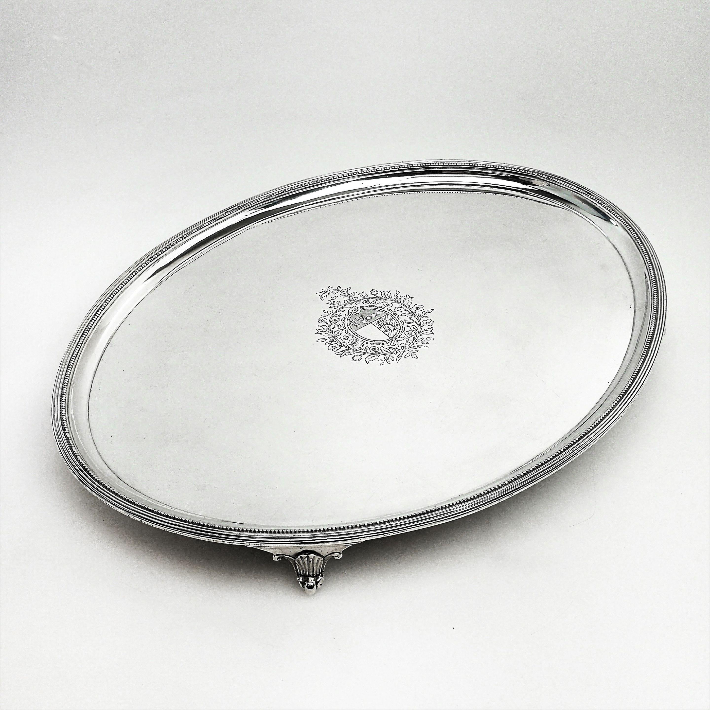 A Classic George III oval solid Silver salver. This large oval  Georgian Salver is simply embellished with a classic beaded border and stands on four scroll feet. The Salver has an impressive crest engraved in the centre. 
 
 Made in London in 1788
