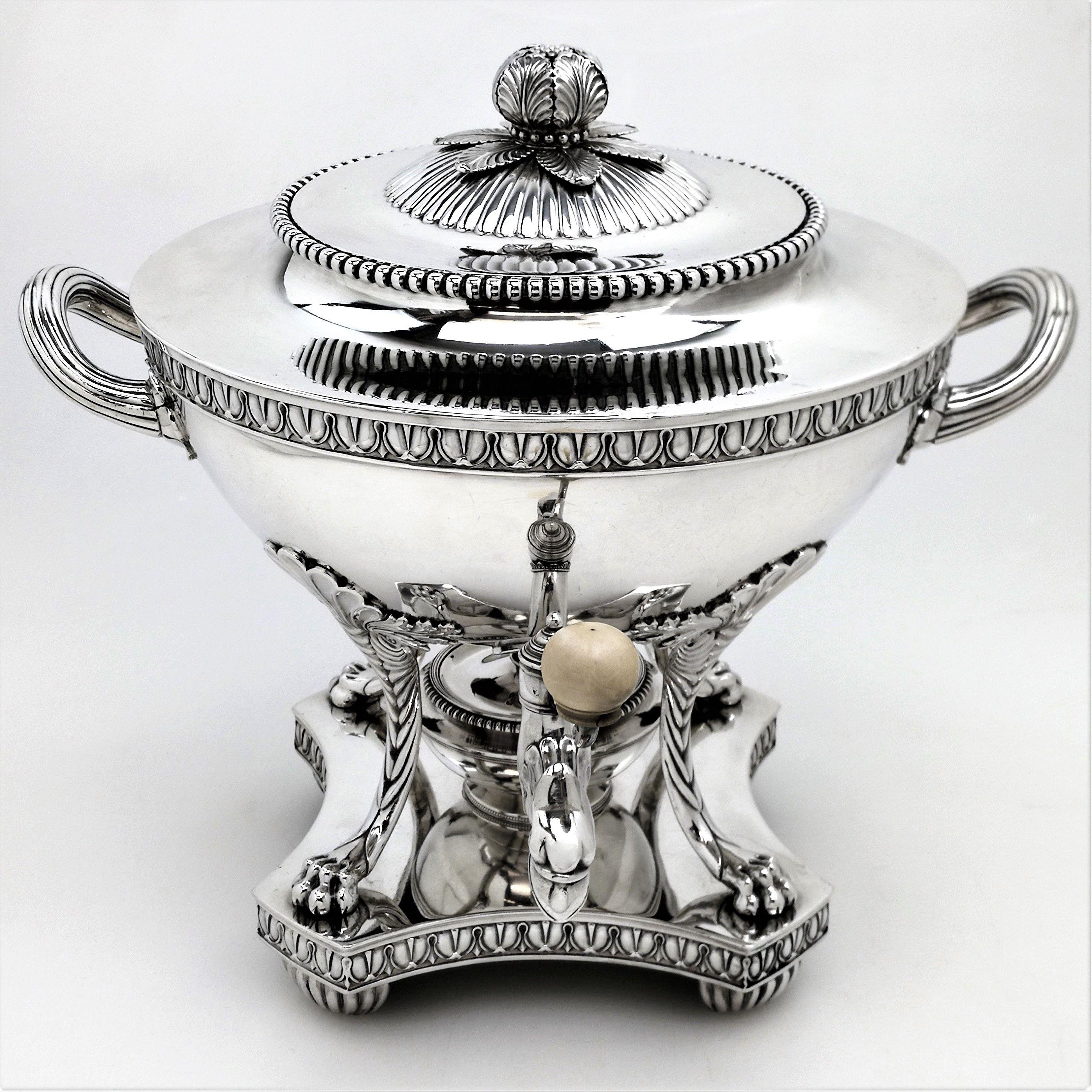 A magnificent antique George III sterling silver tea urn with a hemispherical body supported by four impressive claw feet with shell capitals. The tea urn stands on a shaped base supported by four semi circular chased fluted feet. The rim of the