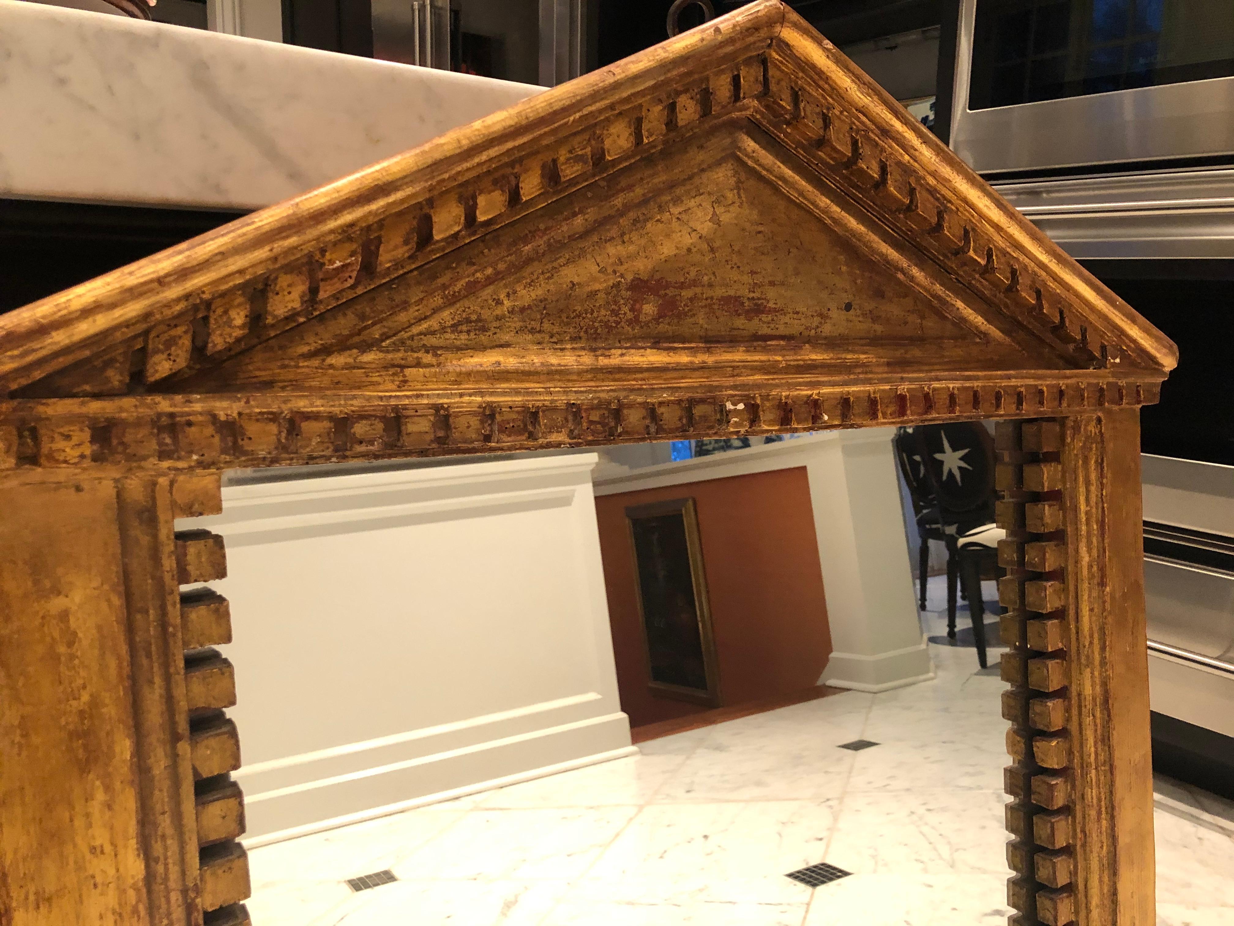 Antique pedimented mirror in the style of George III. Made of giltwood, the patina of the mirror is superb, as is the boldly carved crown molding surround.