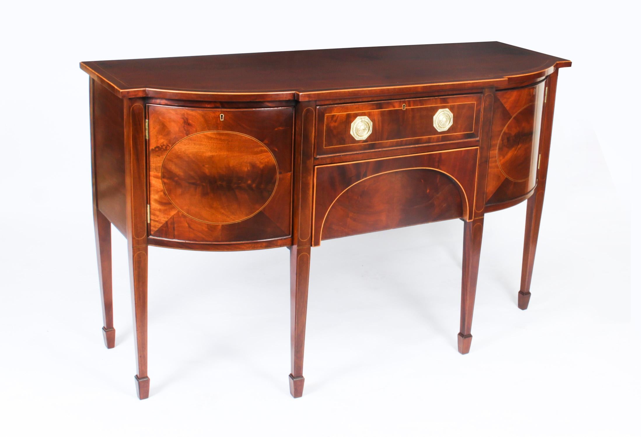 This is a superb antique George III inlaid flame mahogany bowfront sideboard, circa 1780 in date.

The top is banded in flame mahogany with boxwood inlay and has a central frieze drawer above a deep drawer. There is a shaped door on each end and