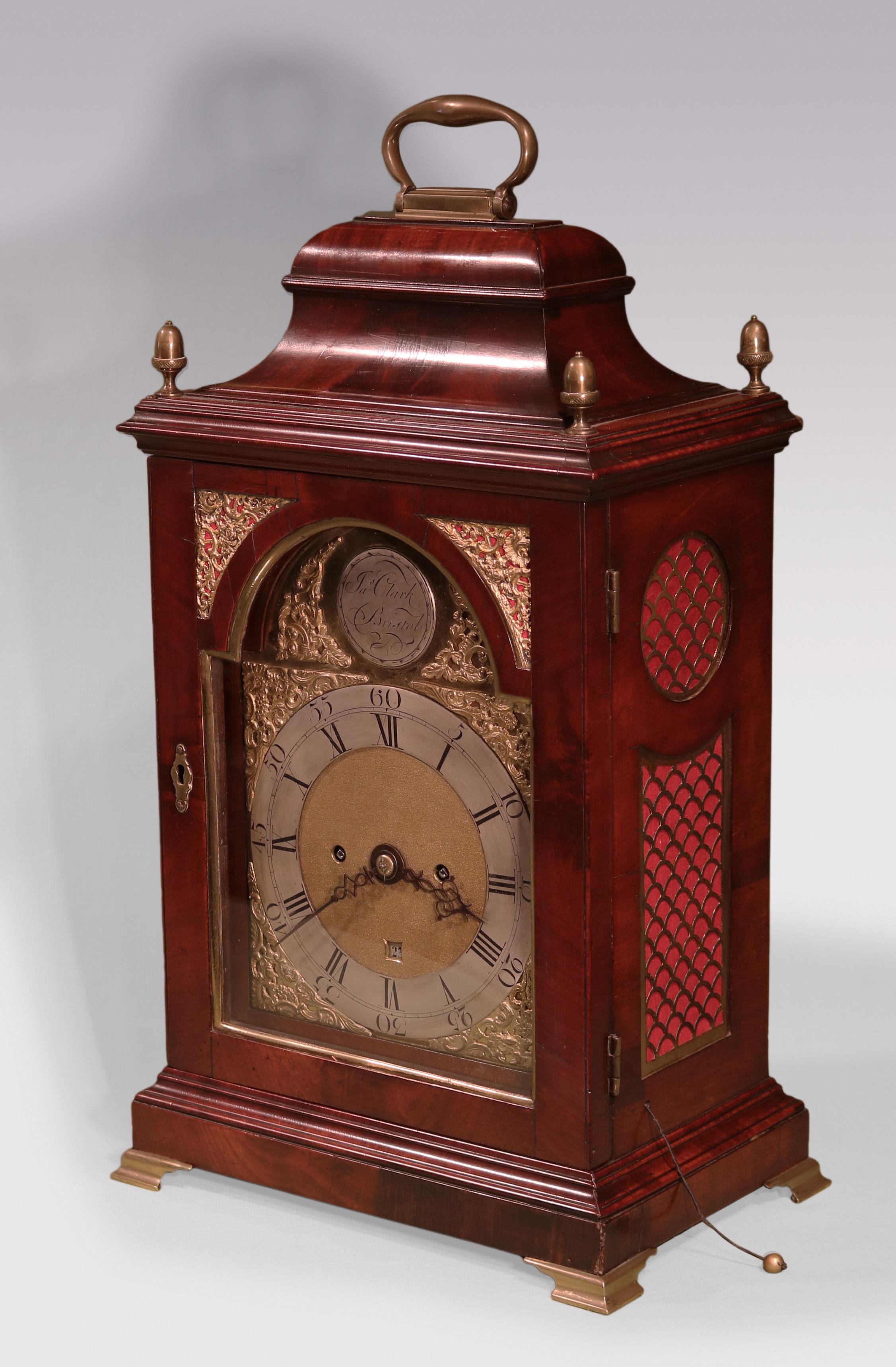 A late 18th Century mahogany Bracket Clock by “Ja's Clark Bristol” with silver dial and gilt brass spandrels, having twin chain fusee movement with verge escapement, contained in bell shaped top surmounted by brass handle & acorn finials on moulded
