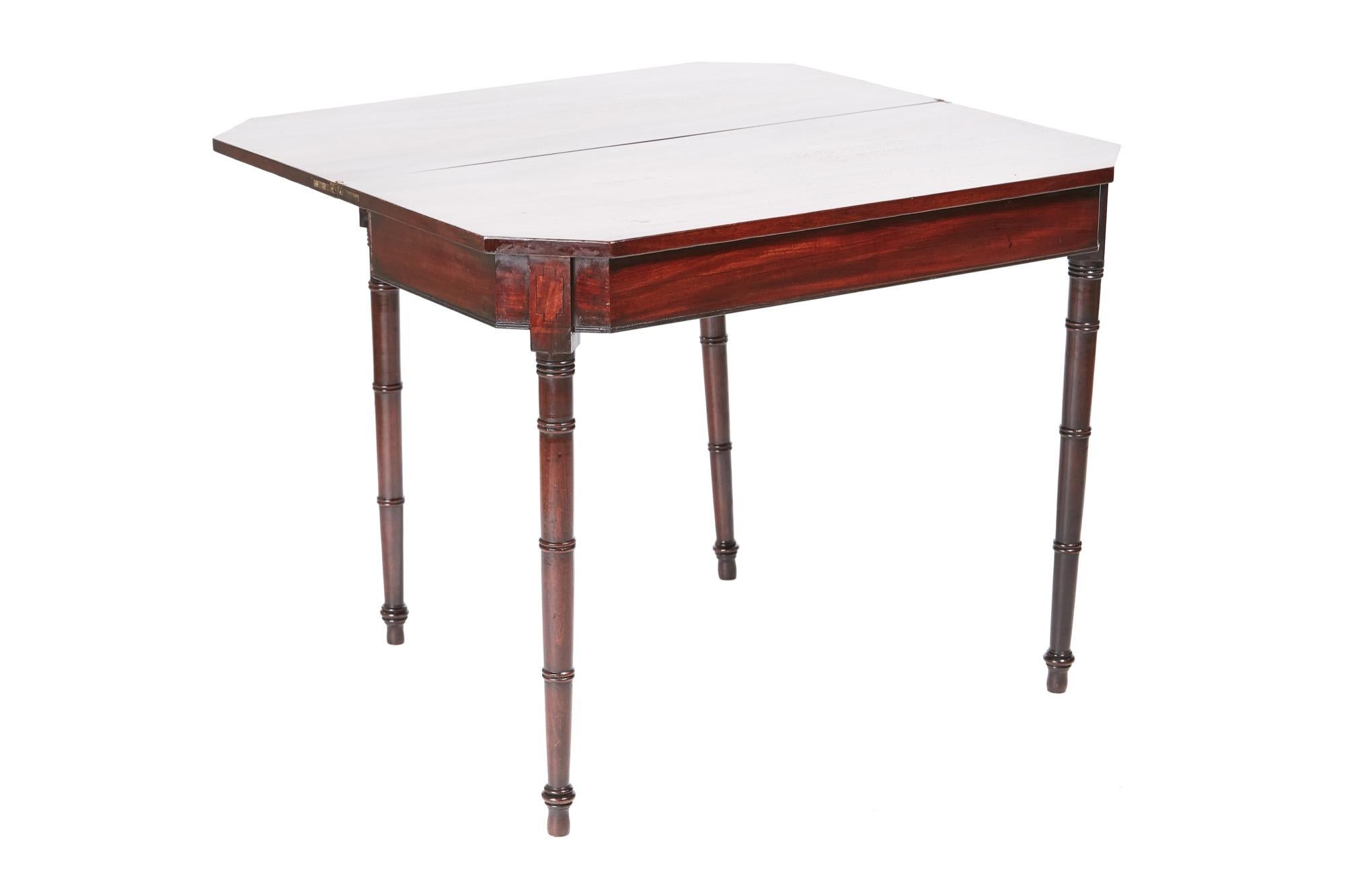 George III antique mahogany tea/side table which has a lovely mahogany folding top with ebony stringing, mahogany frieze with ebony stringing standing on turned tapering legs with unusual turned rings.
  