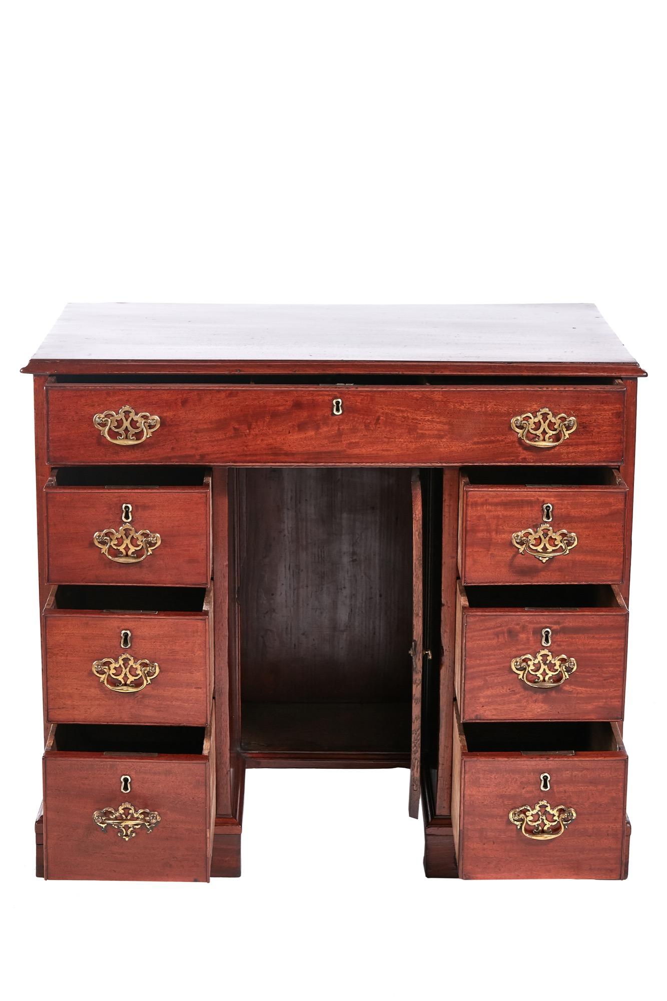 Antique George III antique mahogany writing desk having a splendid mahogany top with moulded edge. One long drawer and six smaller drawers. It is all oak lined with brass handles and has one central cupboard door. It stands on original bracket