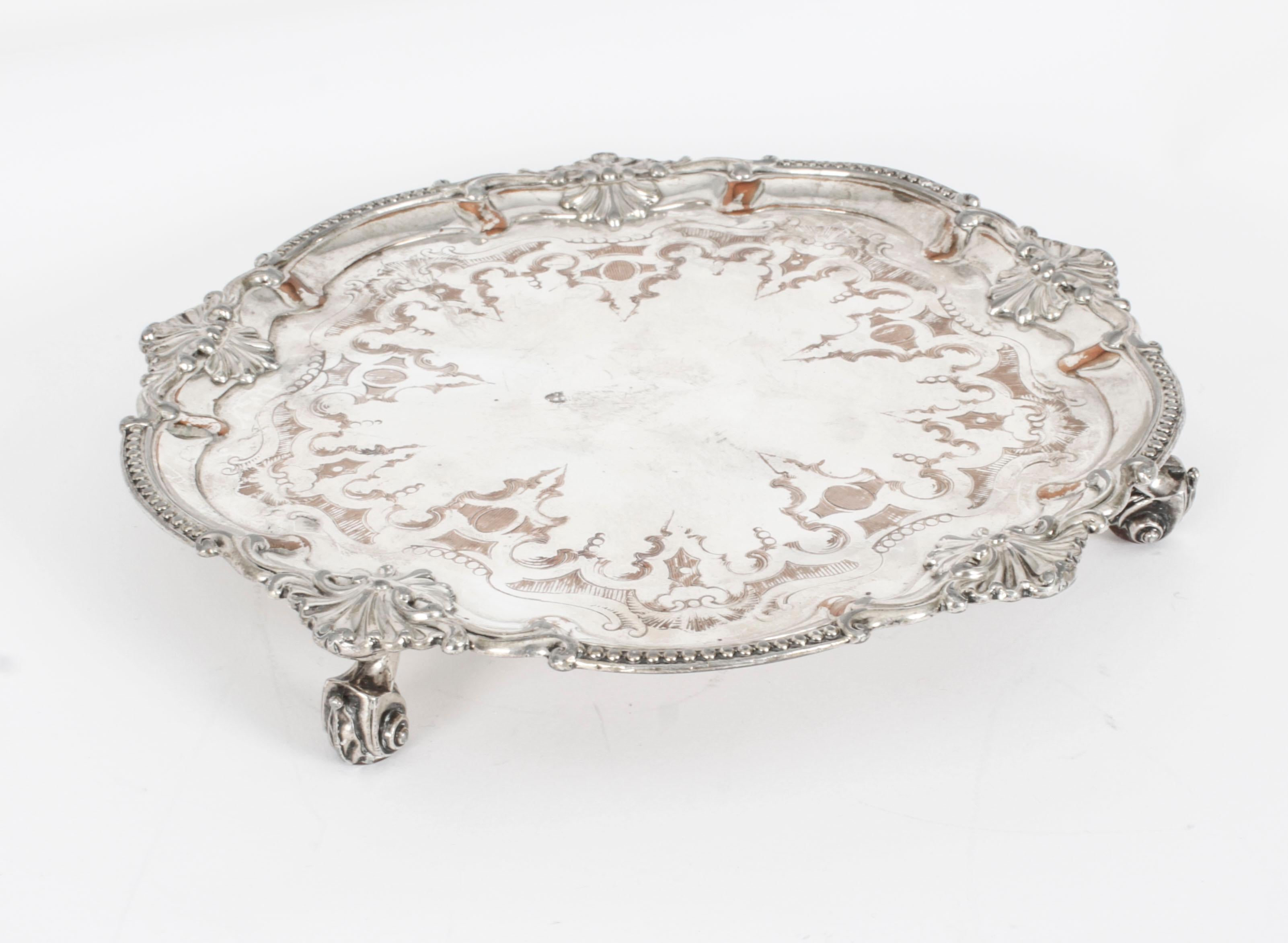 This is an exquisite English antique old Sheffield plate salver, circa 1780 in date.
 
The elegant raised pie crust border shaped salver features hand chased foliate engraving and sits on three cast reticulated feet.
 
Add an elegant touch to