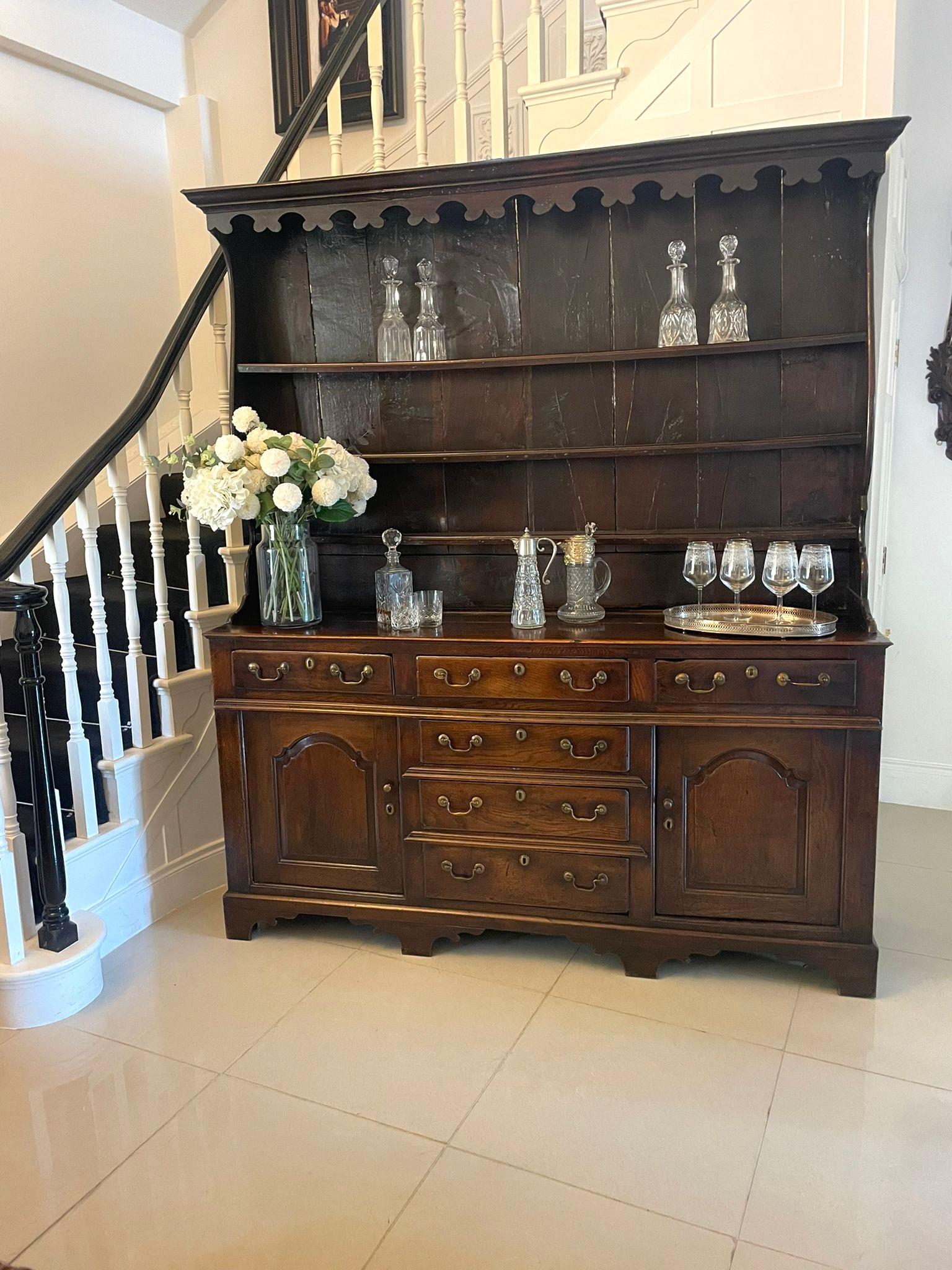 Antique George III outstanding quality oak Welsh dresser and original plate rack having an outstanding quality oak plate rack with original oak boards to the back, attractive carved frieze, three shelves, shaped sides above a magnificent dresser