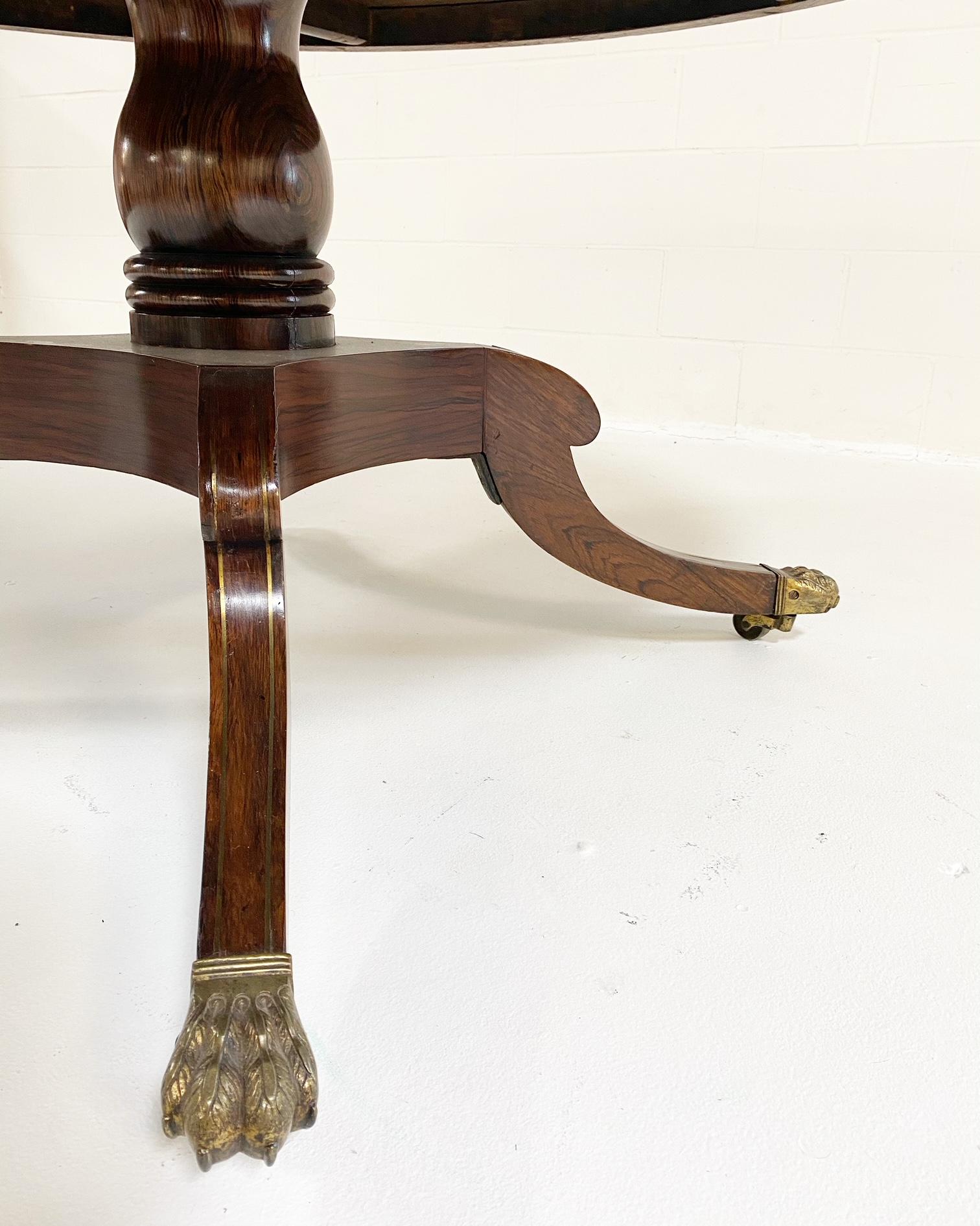Made in England in 1810, this stunning rosewood George III dining table is such a great size. More of an oval shape than perfectly round, it comfortably fits 6 chairs but can certainly accommodate 8. The table is elegantly cross-banded with brass
