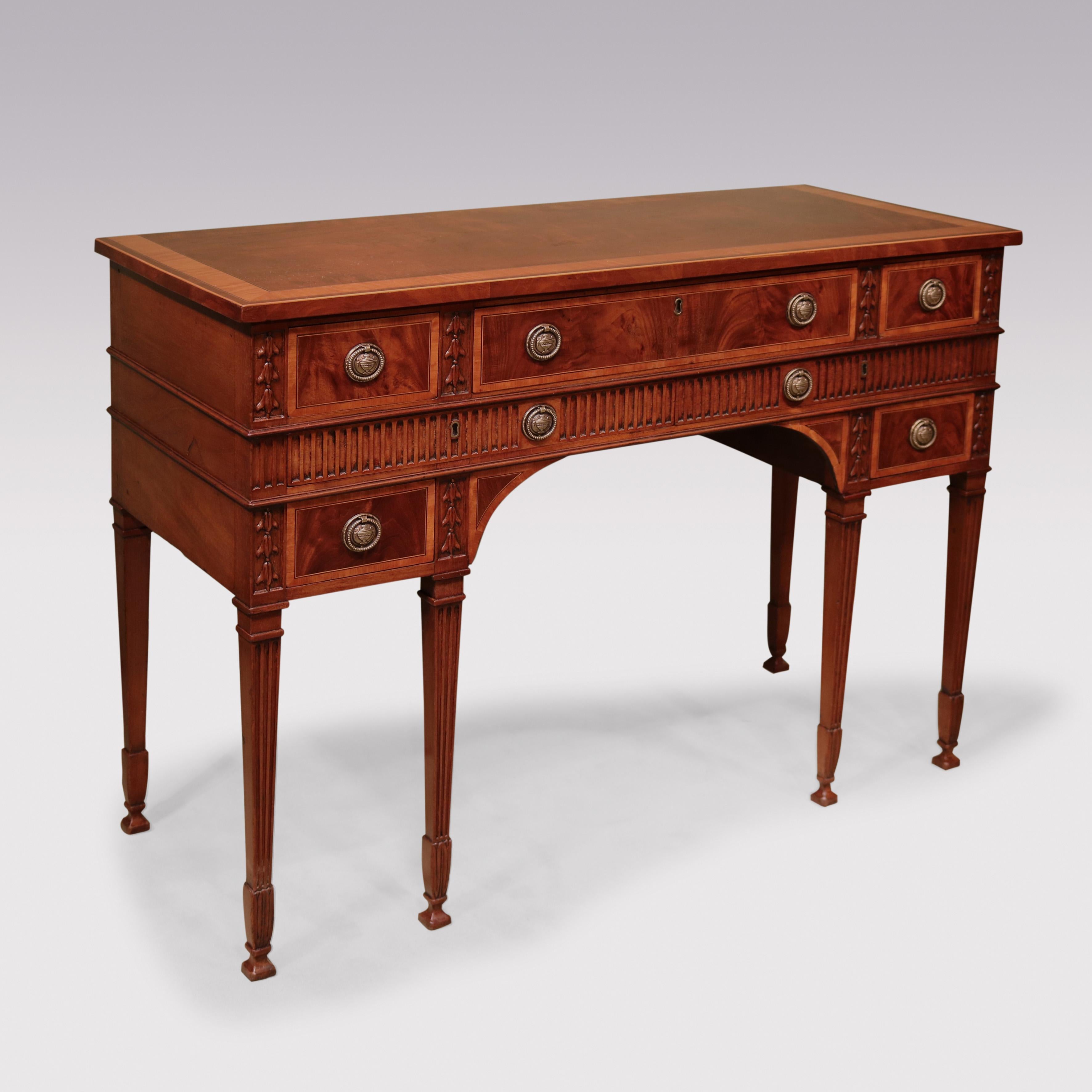 An unusual late 18th Century mahogany Side Table, having satinwood crossbanded top above satinwood banded drawers flanked by carved husk decoration & unusual, fluted frieze with 2 further concealed drawers, supported on fluted tapering legs with
