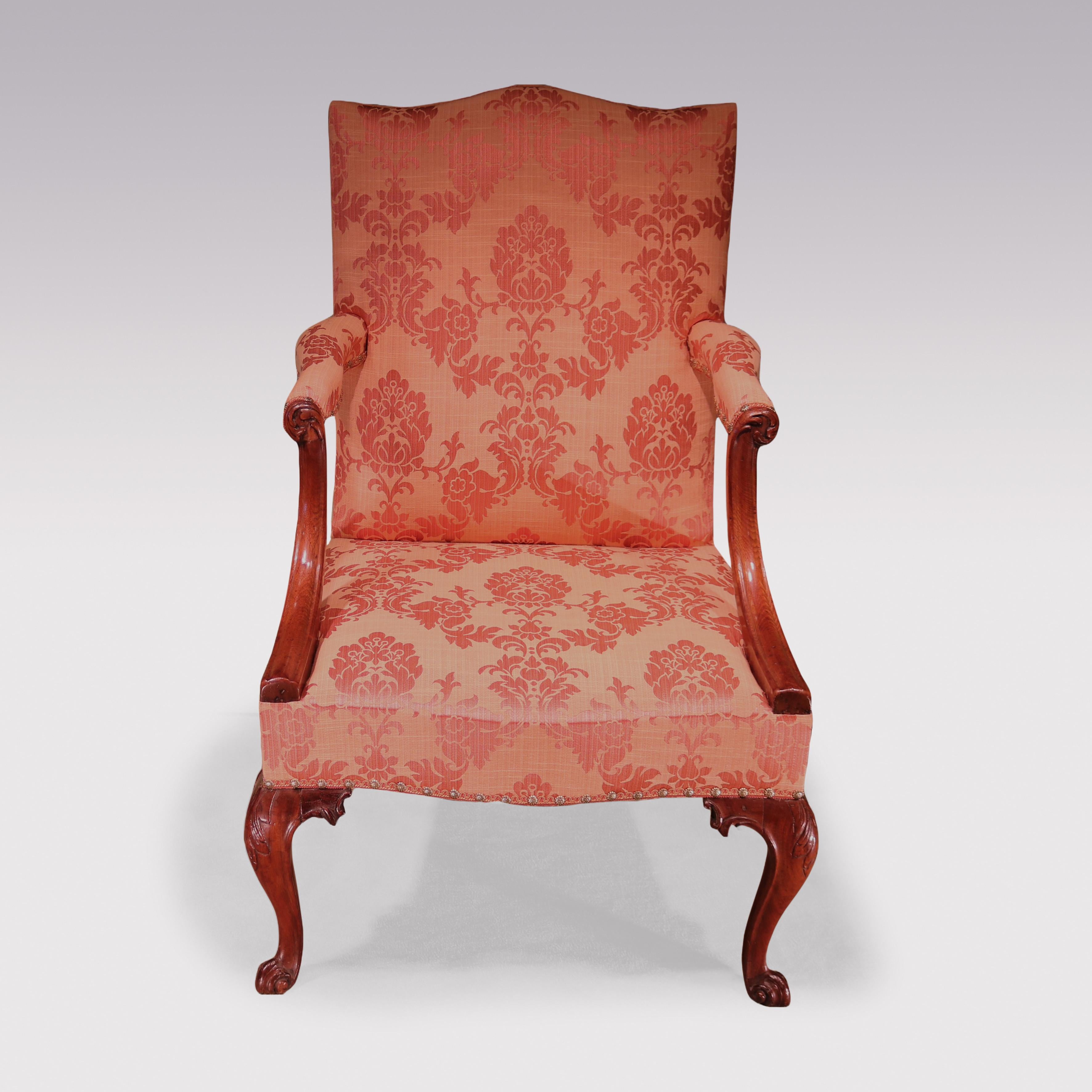 A mid-18th Century mahogany Gainsborough Library Armchair having serpentine top with shaped set-back arms with moulded carving.  The Chair, with serpentine front supported on acanthus carved cabriole legs ending on scrolled front feet, the rear