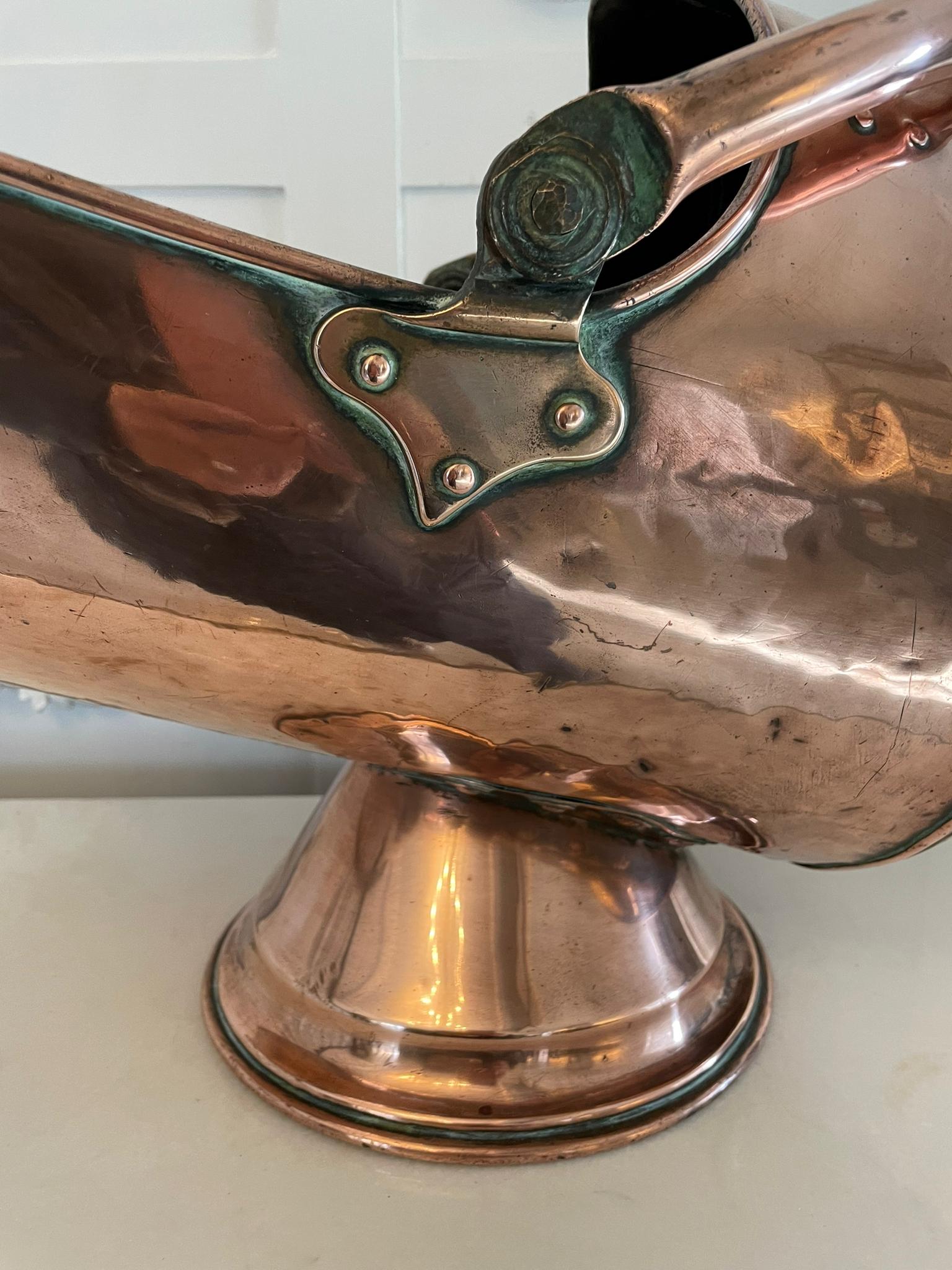 Antique George III quality copper helmet coal scuttle having a quality antique George III copper helmet coal scuttle with original swing carrying handle standing on a circular platform base 

H 34 x W 50 x D 29cm
Date 1800.
 