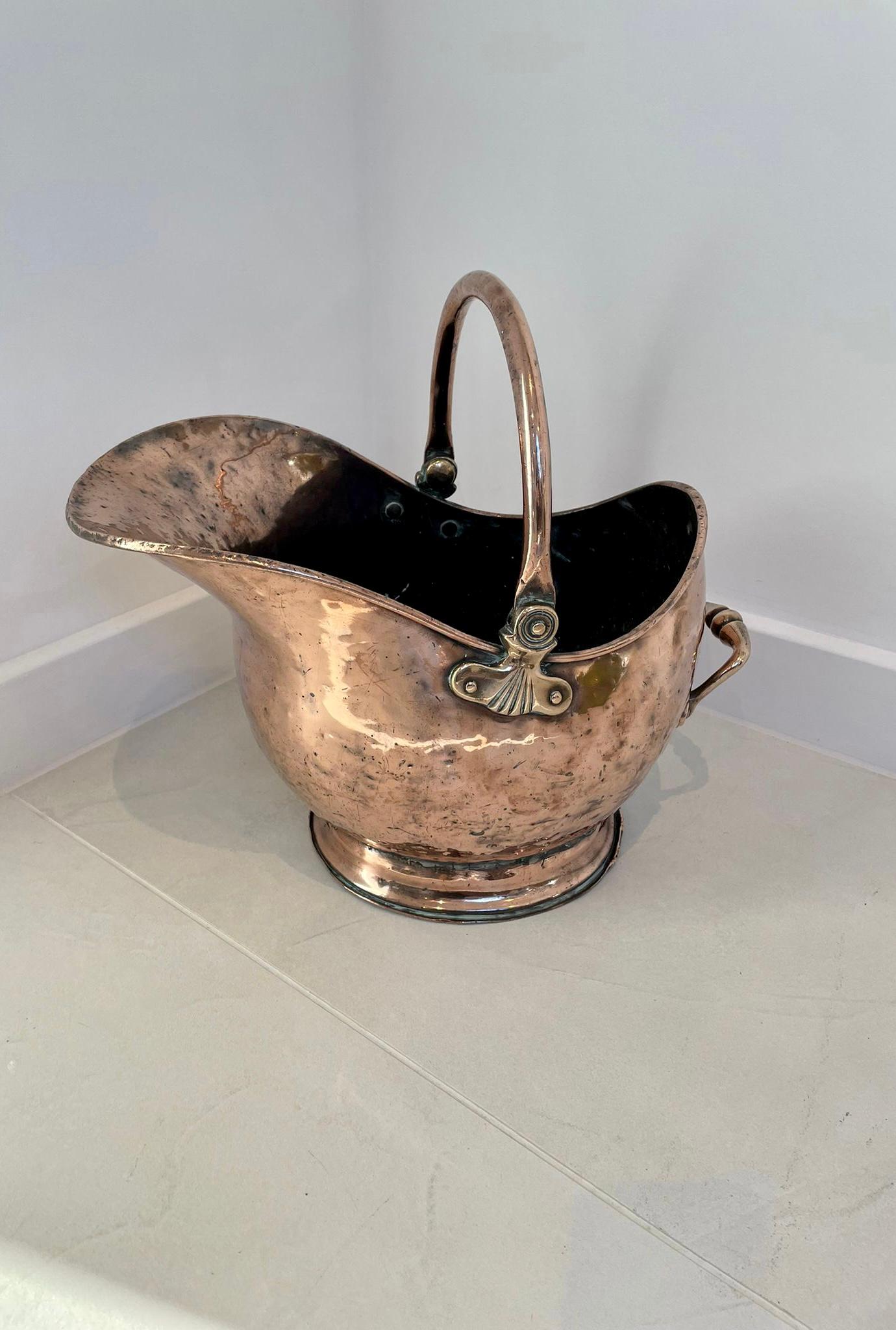 ??Antique George III quality copper helmet shaped coal scuttle having a quality copper helmet coal scuttle with a swing carrying handle and raised on a circular base.

Measures: H 29 x W 17 x D 31cm
Date 1800.
 
