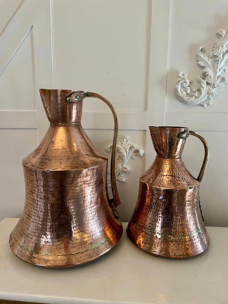 Antique George III quality copper water jug having a quality antique George III large shaped water jug with the original brass shaped handle.

The pictures show it with a larger example which is for sale separately.

Measures: H 34.5 x W 24.5 x