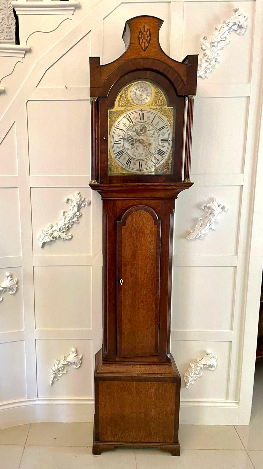 Antique George III quality eight day brass face oak longcase clock having an attractive shaped top with an inlaid shell, oak glazed door flanked by two reeded columns with brass capitals, crossbanded oak door with an arched top flanked by reeded