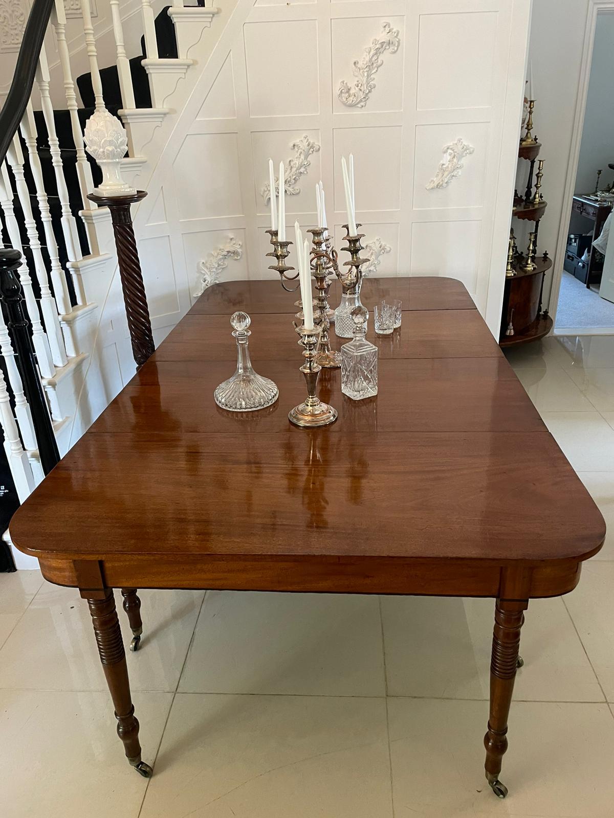 Antique George III quality figured mahogany dining table having a quality figured mahogany top with 2 original extra leaves, mahogany shaped frieze standing on 8 turned tapering mahogany legs with original brass cup castors 

This quality