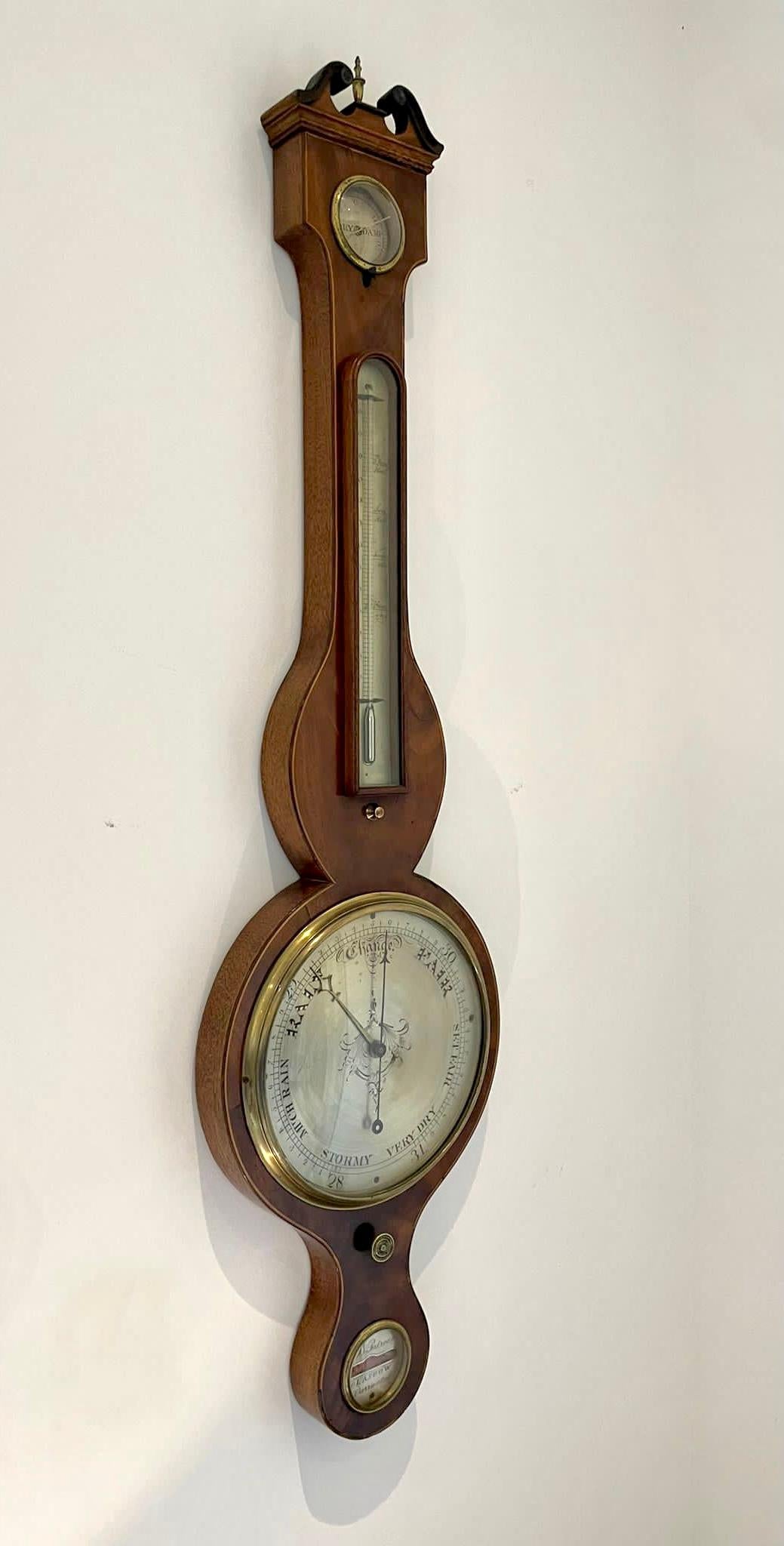 Antique George III quality mahogany banjo barometer having a quality mahogany case with a swan neck pediment and the original turned finial, circular shaped silvered engraved dial with original hands and brass bezel, thermometer, hygrometer, spirit