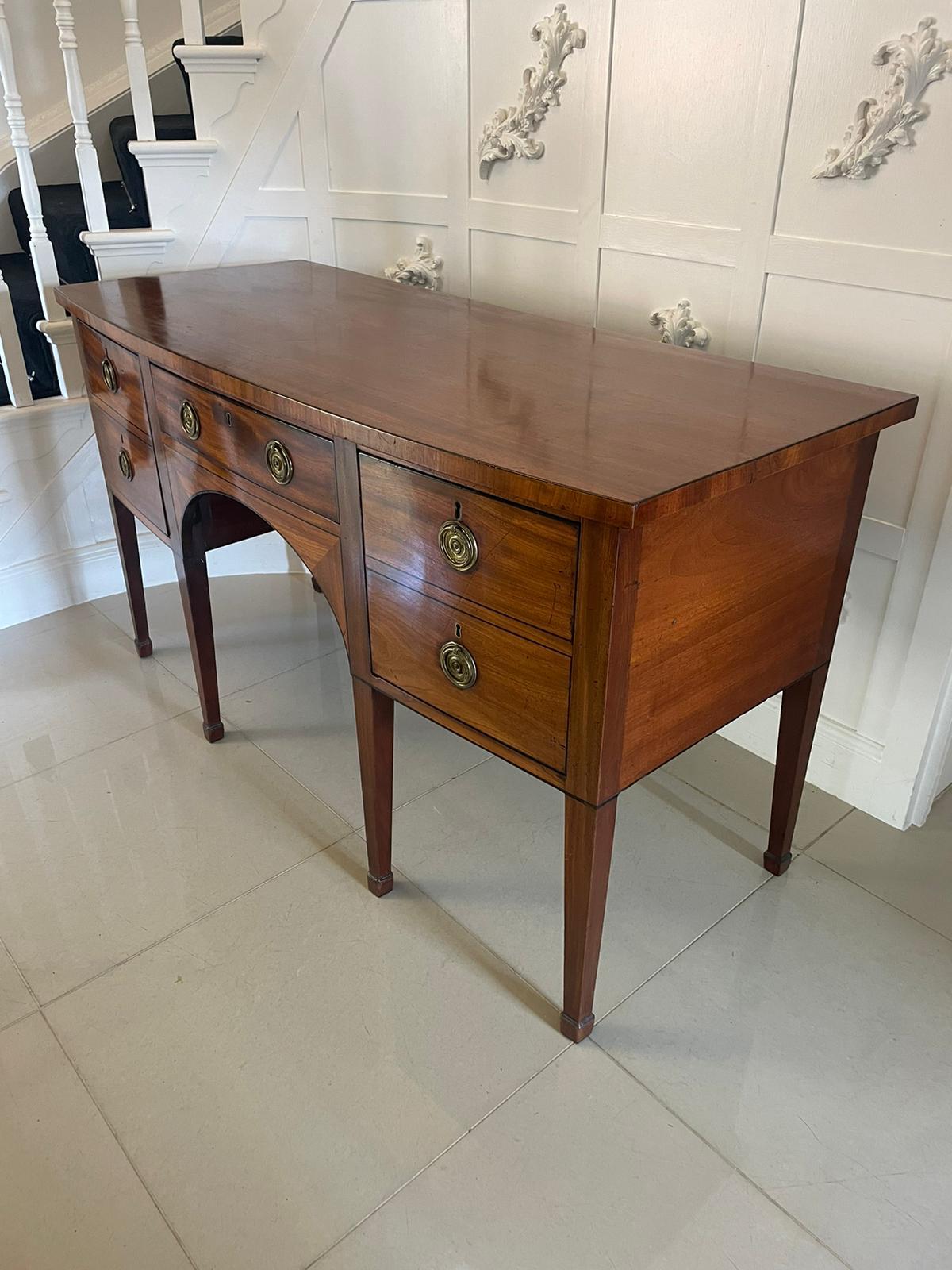 Antique George III quality mahogany bow fronted sideboard having a bow fronted figured mahogany top with inlaid ebony stringing above 3 bow fronted oak lined inlaid ebony drawers with circular brass handles standing on square tapering legs with
