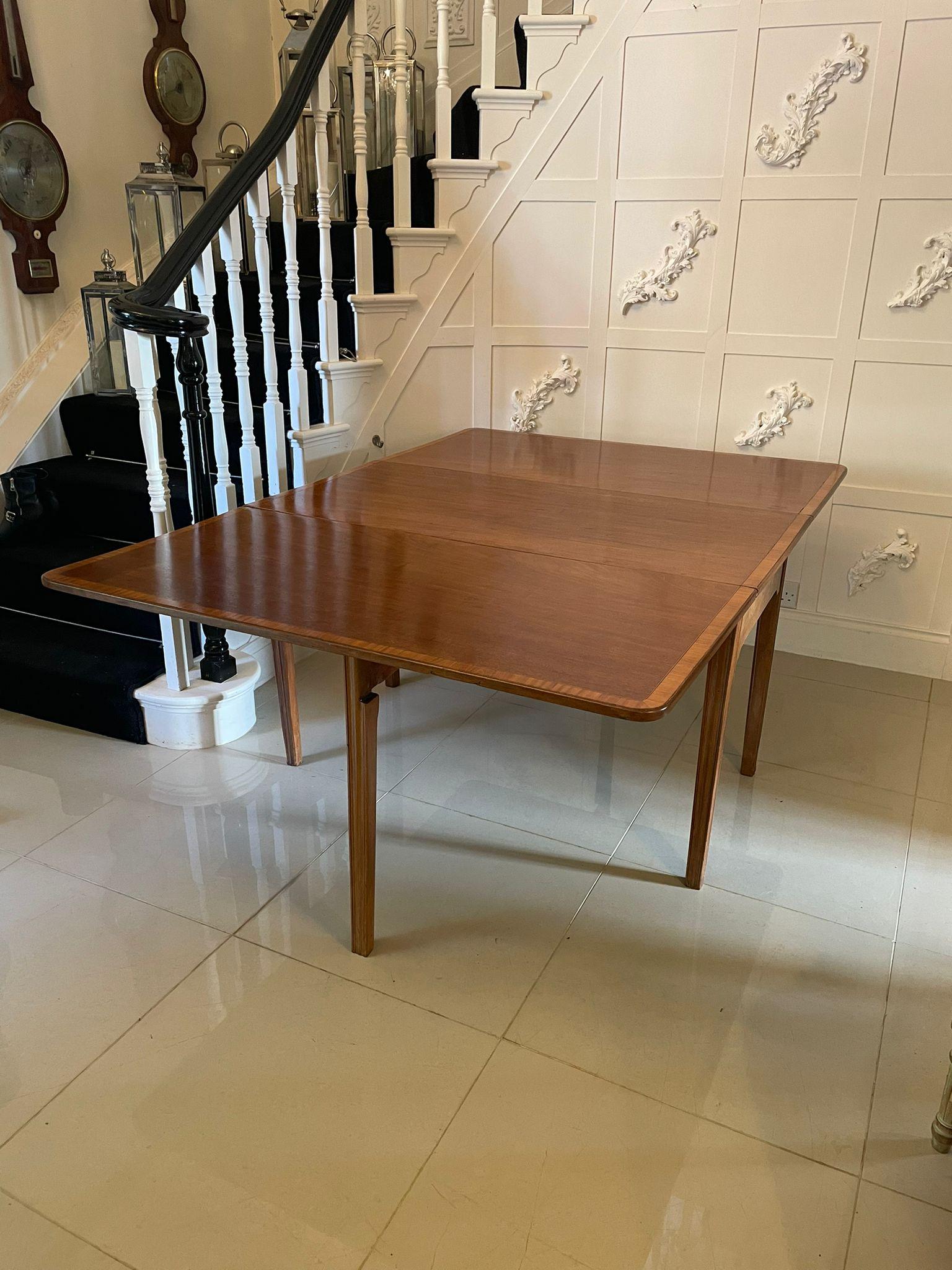 Antique George III quality mahogany drop leaf dining table having a quality mahogany top with two drop leaves beautifully crossbanded in satinwood and standing on six moulded legs with two gatelegs.

An attractive example having a very desirable