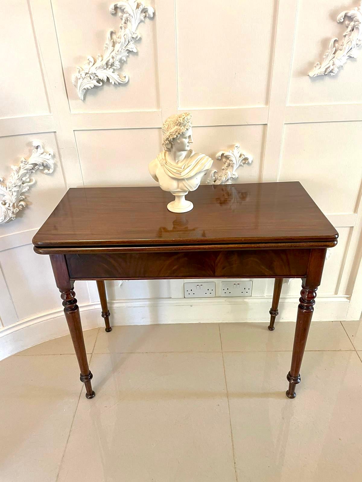 Antique George III quality mahogany fold over tea/side table having a quality mahogany fold over top opening to reveal a polished interior, mahogany shaped frieze, standing on four elegant turned tapering legs with bun feet.

Measures: 77.5 x 91 x