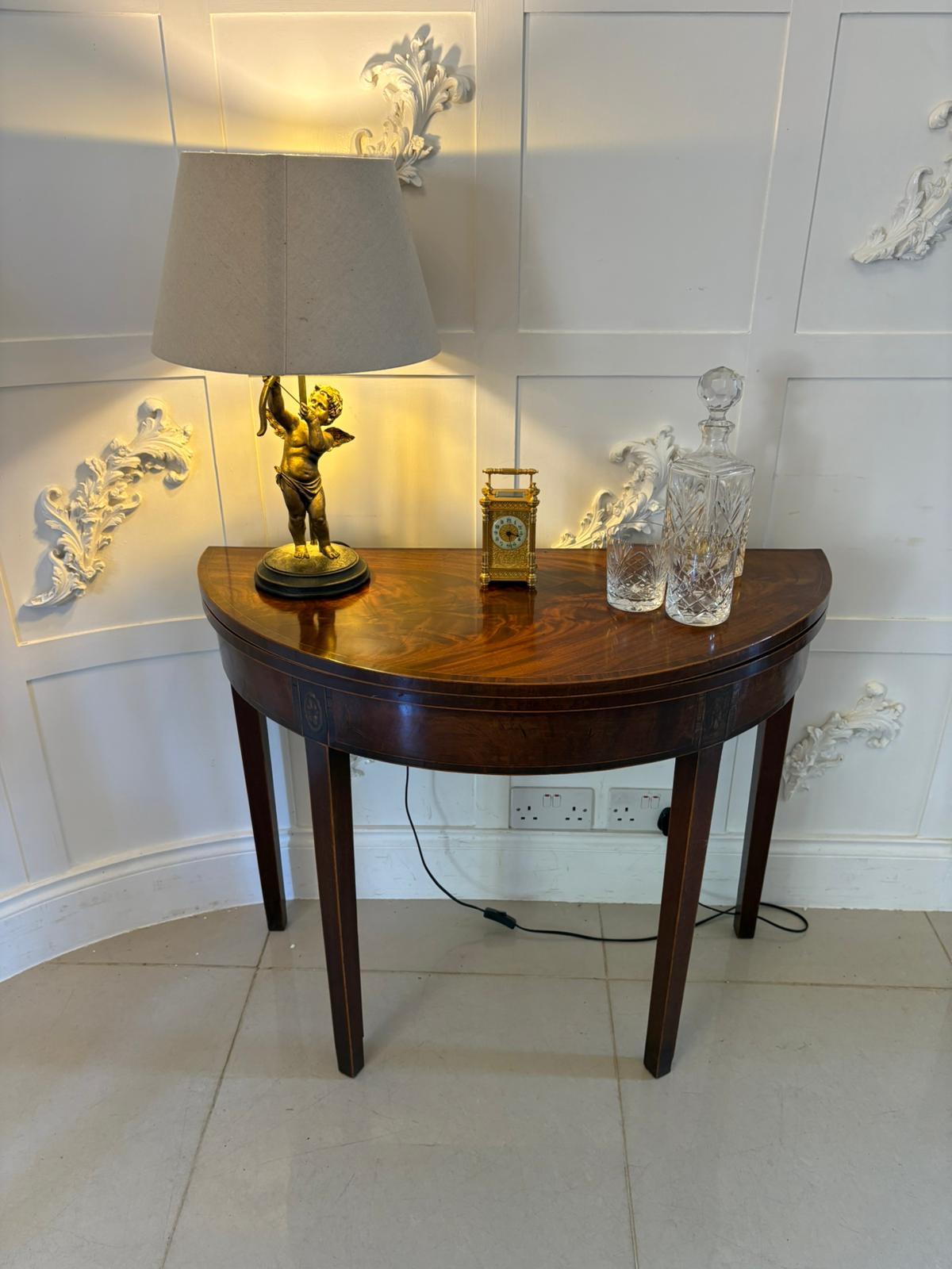 Antique George III quality mahogany inlaid demi lune shaped card/console table having a quality mahogany demi lune shaped top with satinwood crossbanding opening to reveal a baize interior, mahogany frieze with oval inlaid satinwood shells standing