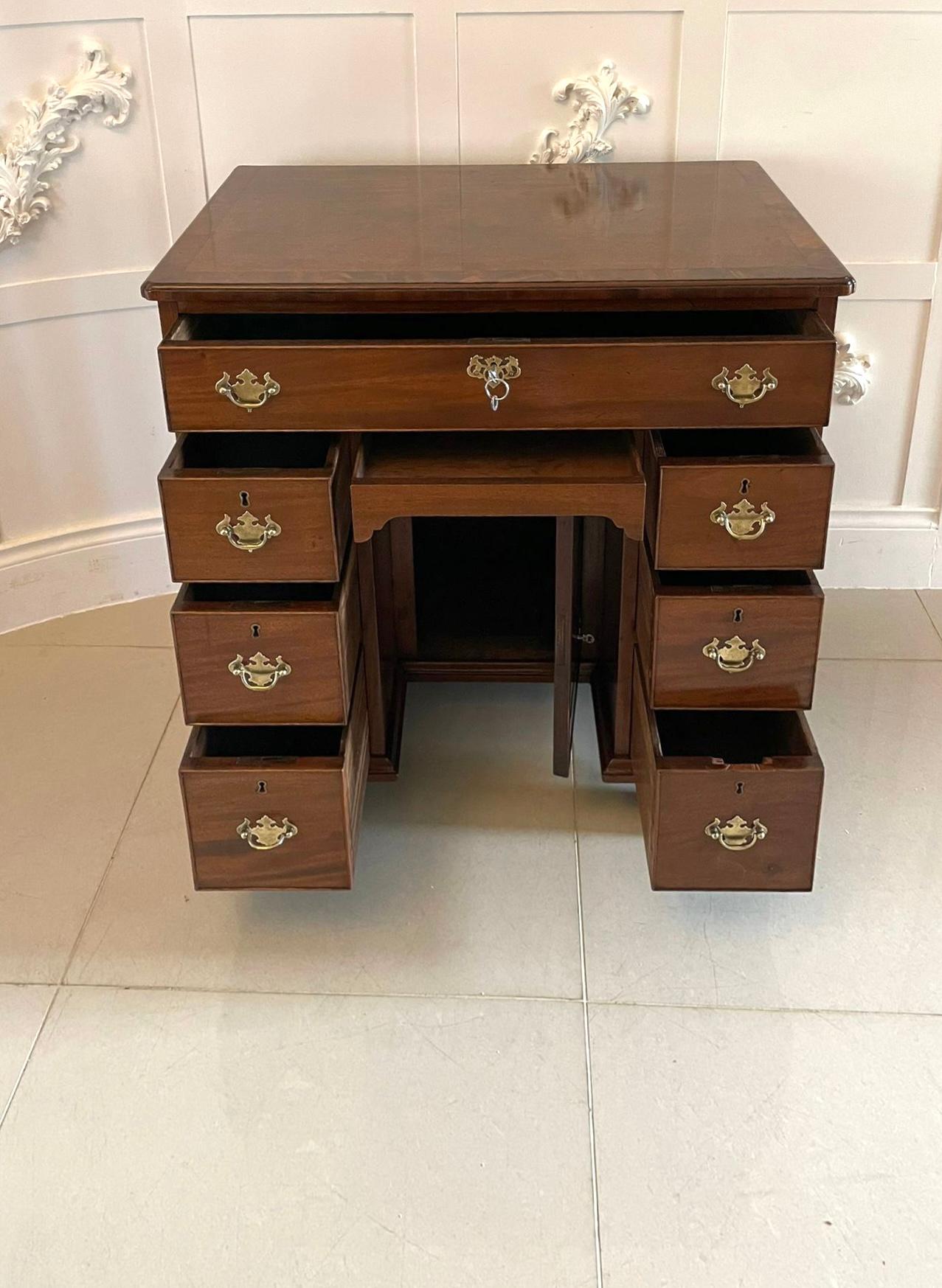 Antique George III quality mahogany knee hole desk having a quality mahogany rectangular shaped crossbanded top with a moulded edge above one long and six small cockbeeded oak lined drawers with original brass handles, secret drawer to the knee hole