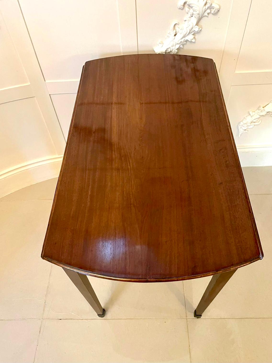 Antique George III quality mahogany Pembroke table having a quality mahogany oval top with two drop leaves and a moulded edge above an attractive bow fronted cockbeeded drawer with original brass handles standing on four elegant square tapering legs