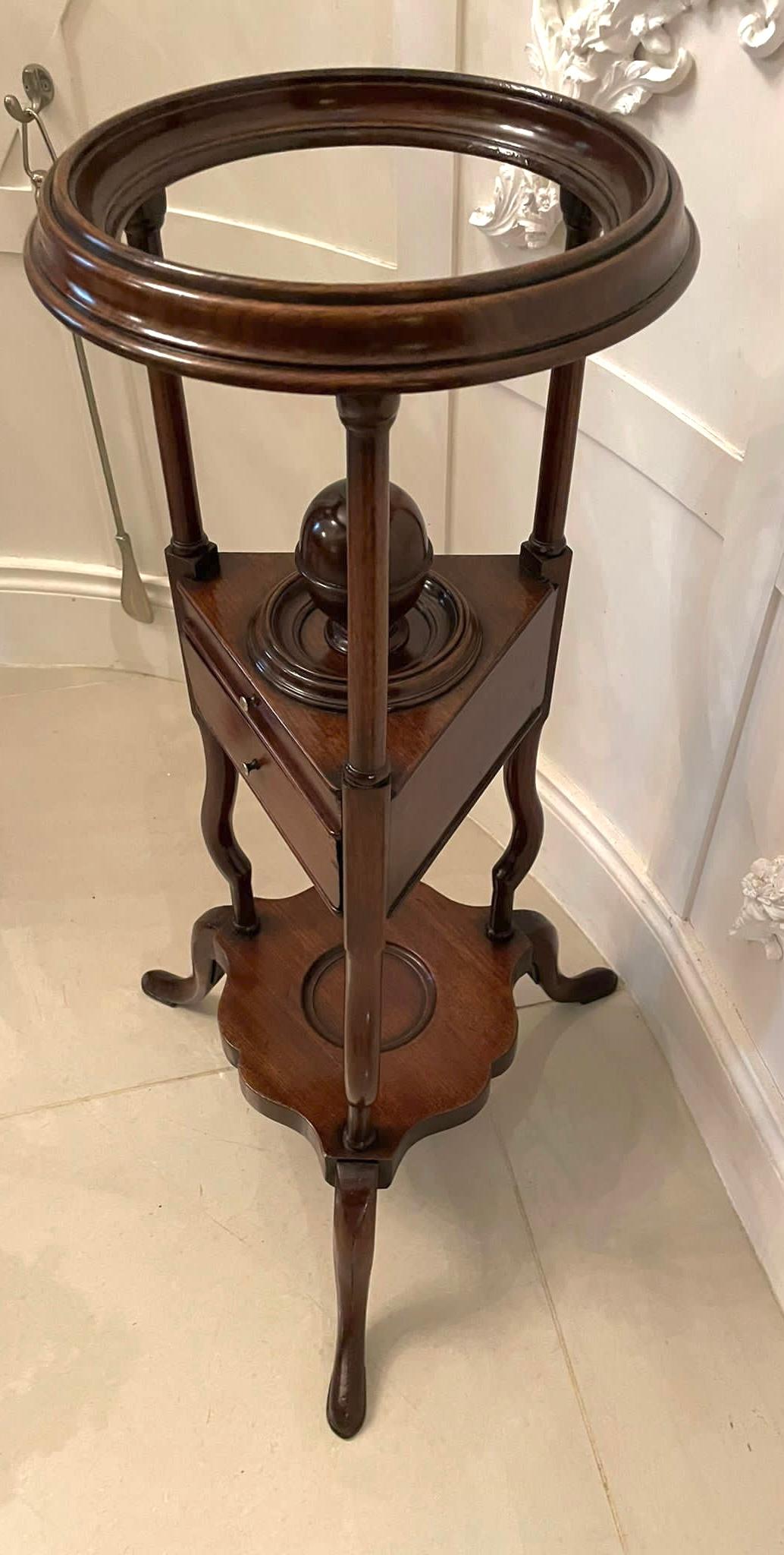 Antique George III quality mahogany shaving stand having a quality circular top supported by three turned mahogany columns united by two drawers and an unusual mahogany urn with a lift off lid above three shaped supports united by a shaped mahogany