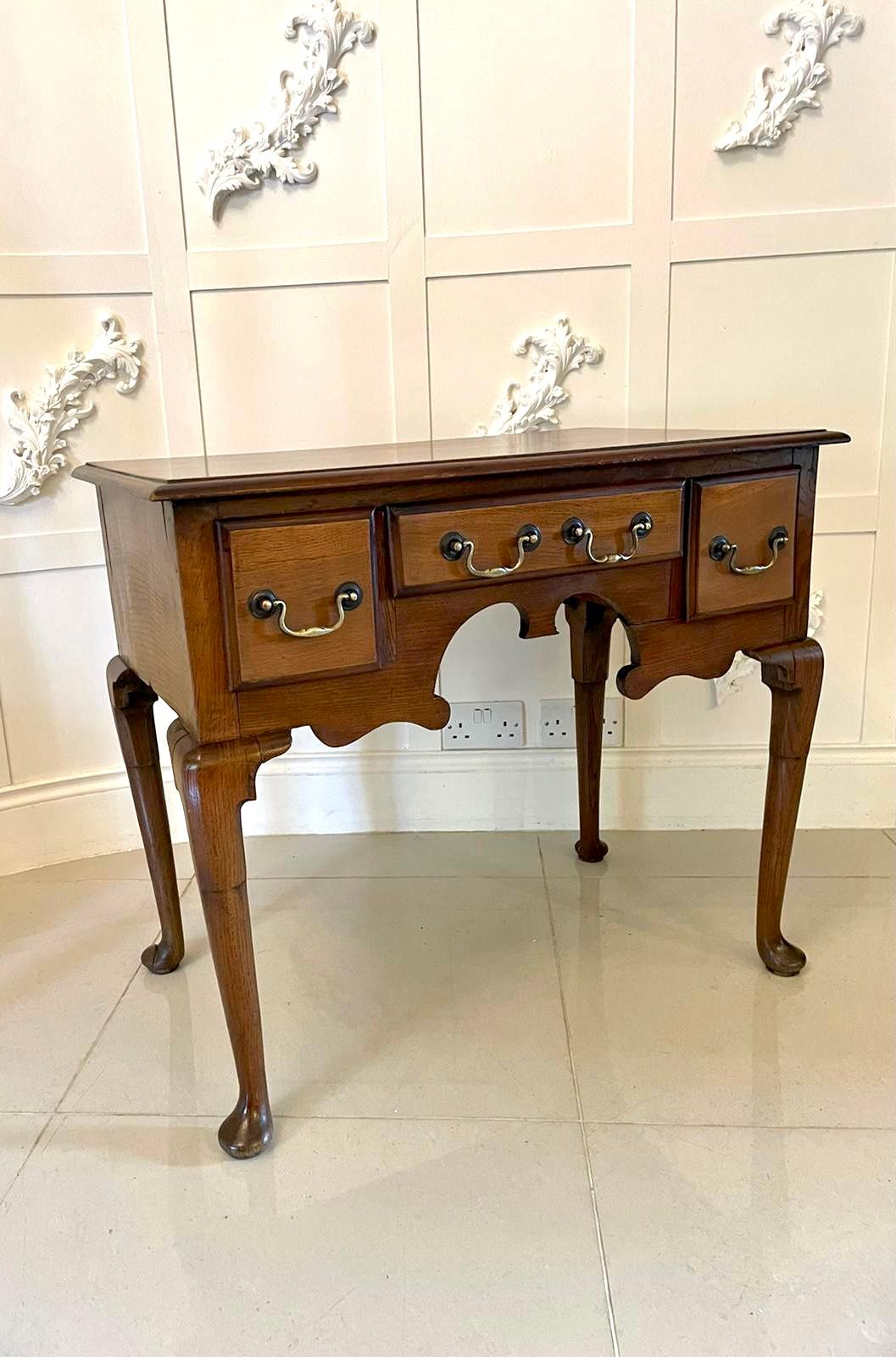 Antique George III quality oak lowboy having a quality rectangle oak top with a moulded edge above three drawers with brass swan neck handles and a shaped apron. It is raised upon four shaped cabriole legs with pad feet.

A lovely example in