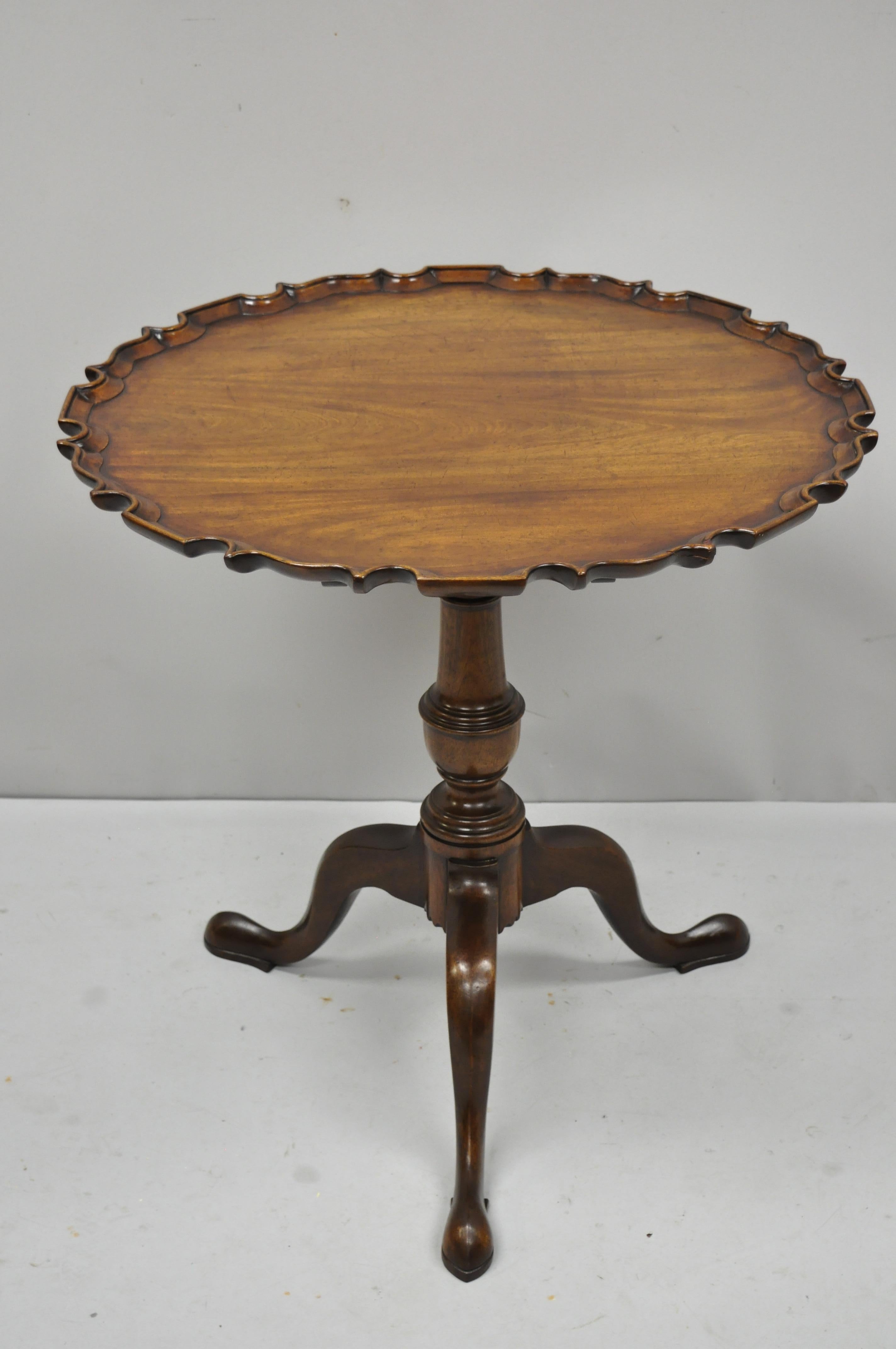 Antique George III Queen Anne mahogany pie crust tilt top tea table by Caledonian. Item features finely carved pie crust top, tripod Queen Anne base, tilt top, solid wood construction, beautiful wood grain, original tag, quality craftsmanship, great