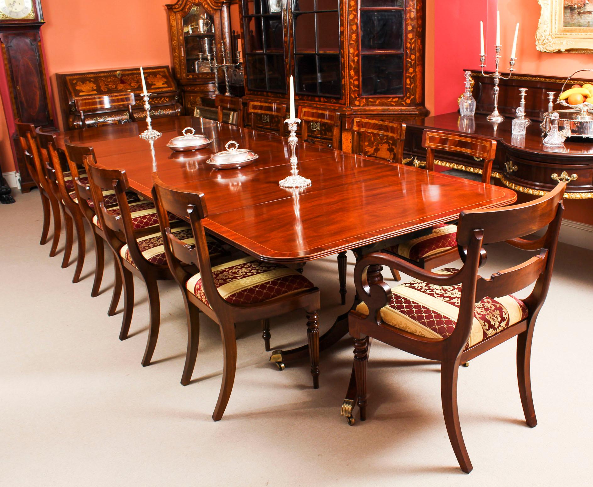 This is an elegant antique George III Regency dining table, dating from circa 1825.

The table is raised on three bases each with turned pillars, four hipped and swept square legs terminating in brass caps and castors. It has two leaves which can