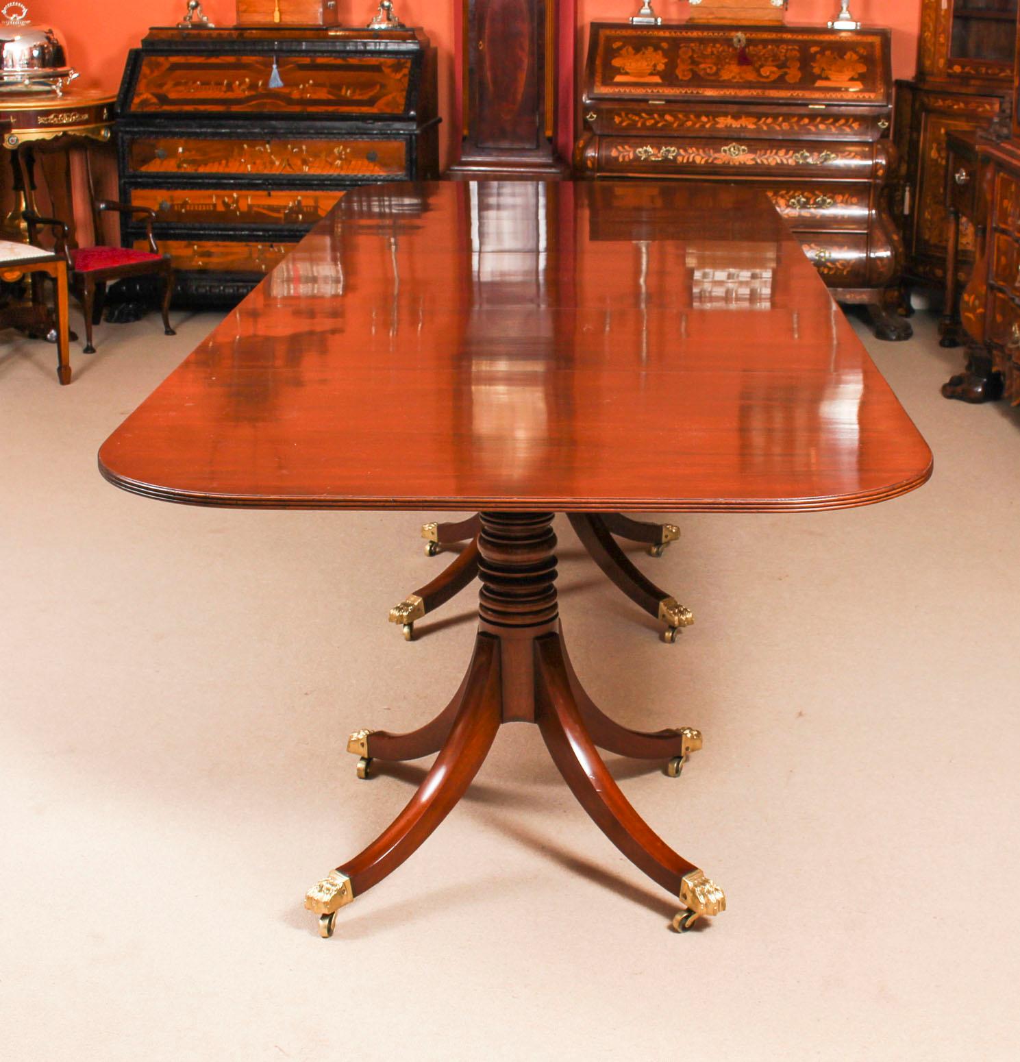 This is an elegant antique George III Regency Period dining table, circa 1820 in date.

The table is raised on three bases each with turned pillars, sabre legs terminating in brass claw caps and castors. It has two leaves which can be added or