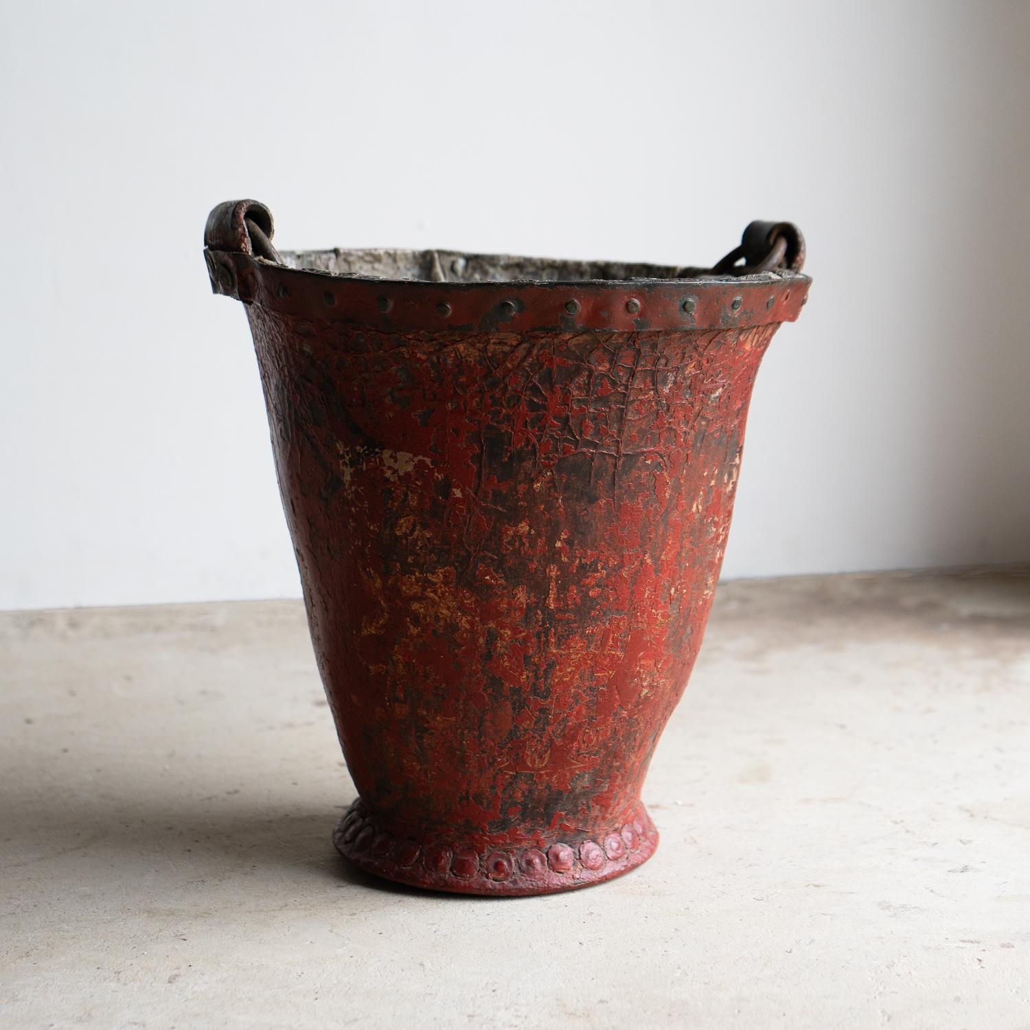 SECCHIO DA FUOCO IN PELLE ANTICA

Un pezzo estremamente decorativo e ricco di carattere.

Pelle di grosso calibro formata da rivetti e cinturino con borchie di ferro.

Resti di strati di vernice antica sotto lo strato rosso superiore che