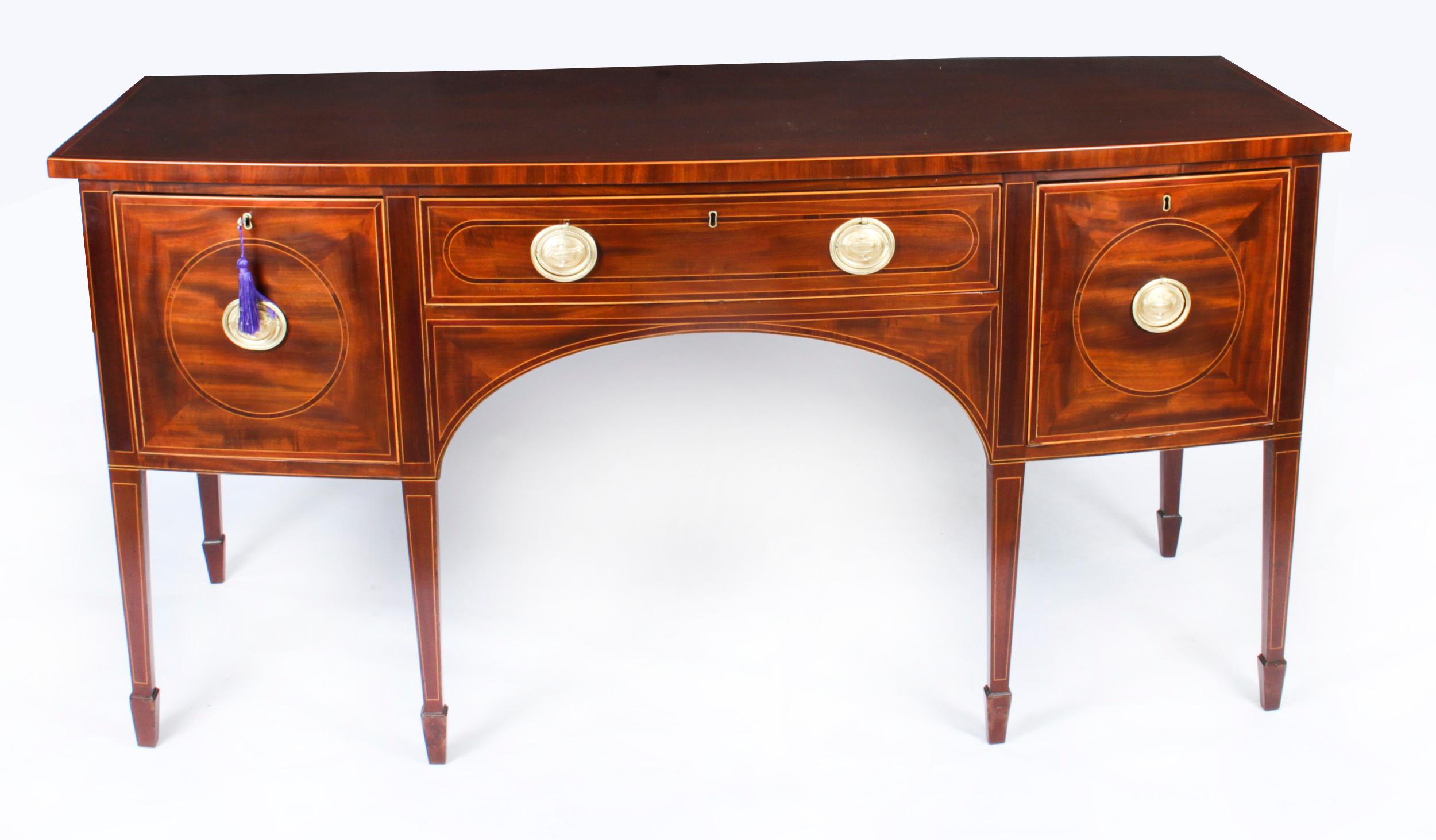 This is a superb antique Scottish flame mahogany and inlaid bowfront sideboard made in the reign of George III, circa 1790 in date.
 
The splendid shaped top is above a central frieze drawer flanked by cellarette drawers, all with their original