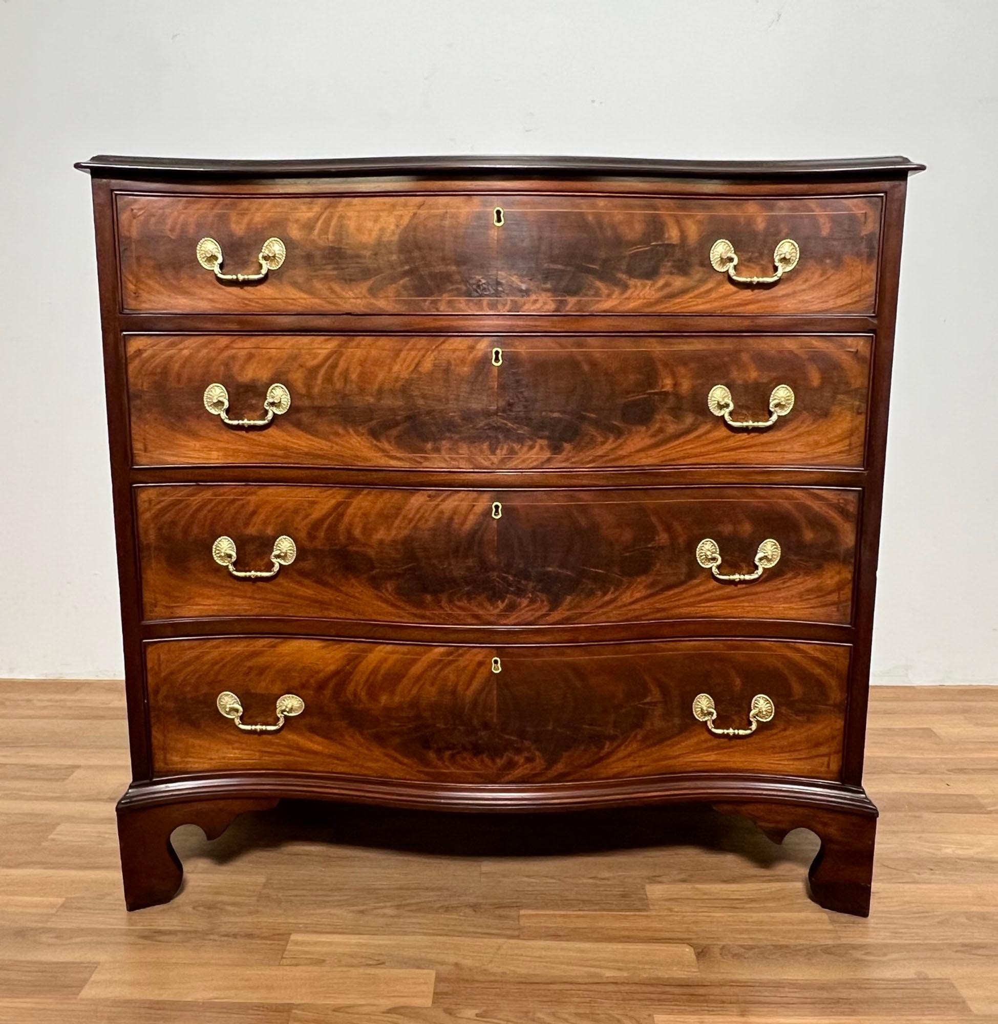 A fine antique George III serpentine chest, ca. 1790, with flamed mahogany drawers over bracket feet. Original brasses recently polished but remain unlacquered so will patinate naturally.