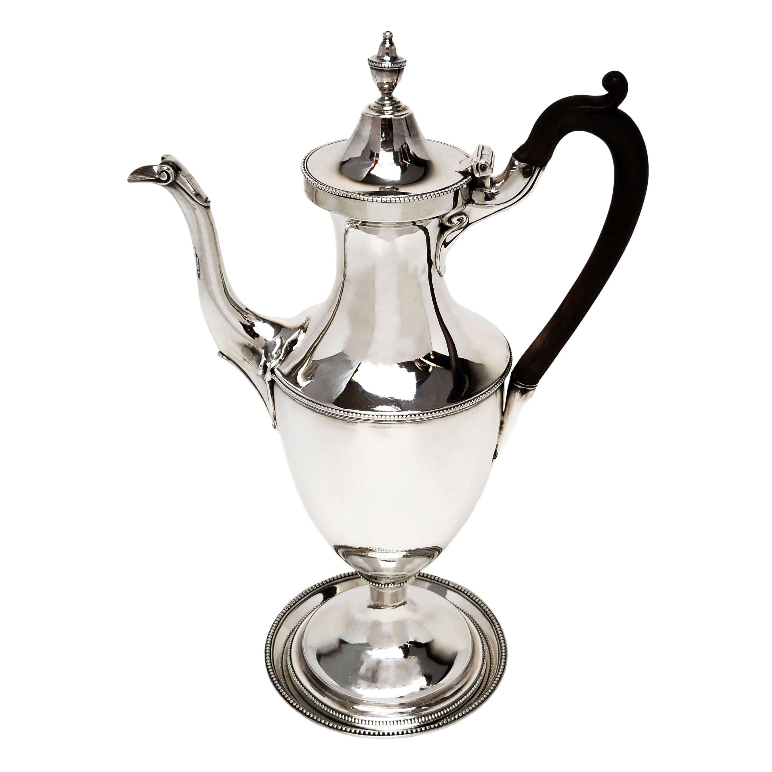 An impressive Antique George III Sterling Silver Coffee Pot on a Silver Stand. This classic Georgian Coffee Pot has a subtle bead edged border on the lid, shoulder, column and base. The Coffee Pot has a wooden handle. The Stand has a round form and