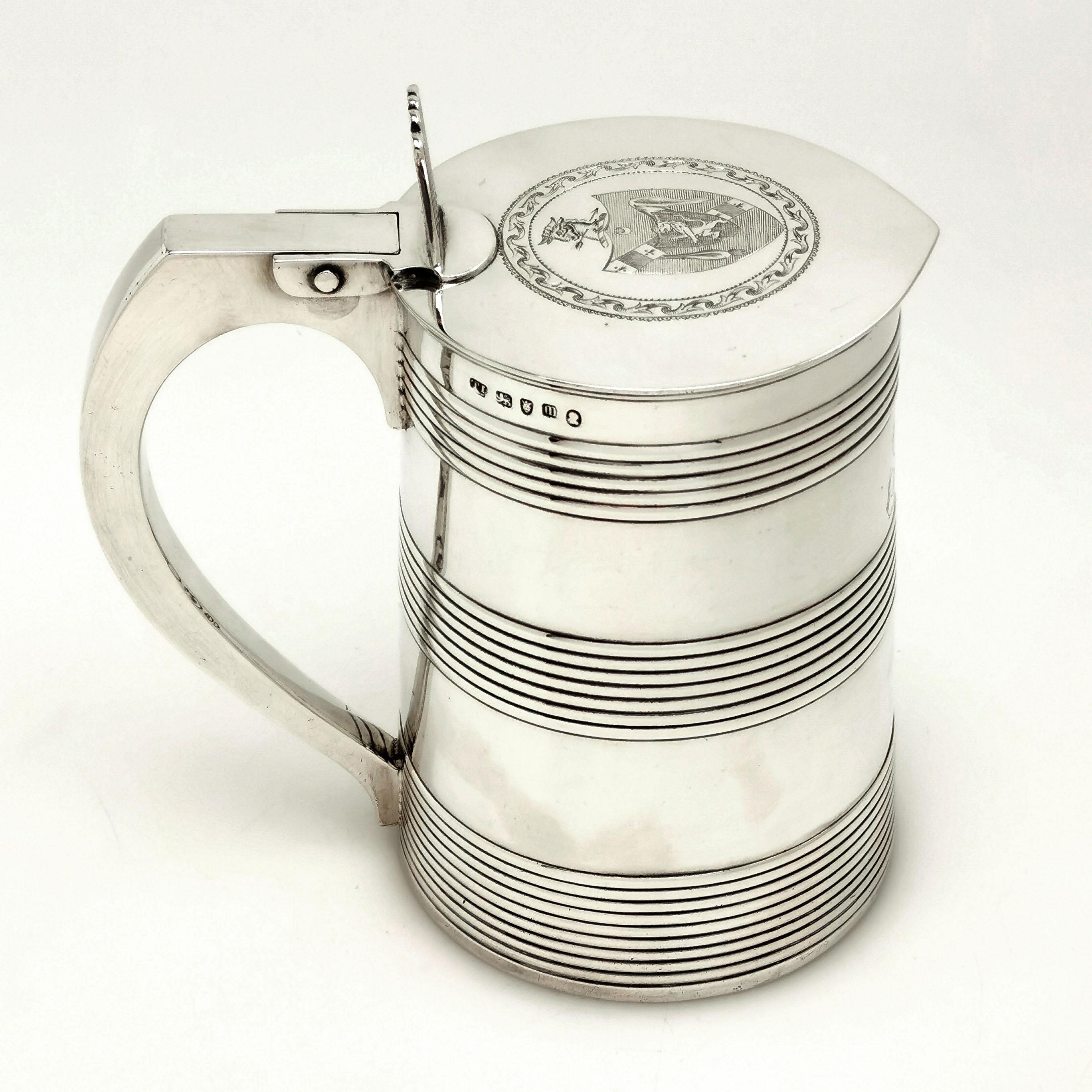 A gorgeous antique George III antique solid silver lidded tankard in a Classic cooper style design. The Tankard has tree reeded bands on the tapered straight sided body indicating the strap-work on a barrel. The flat hinged lid has an impressive
