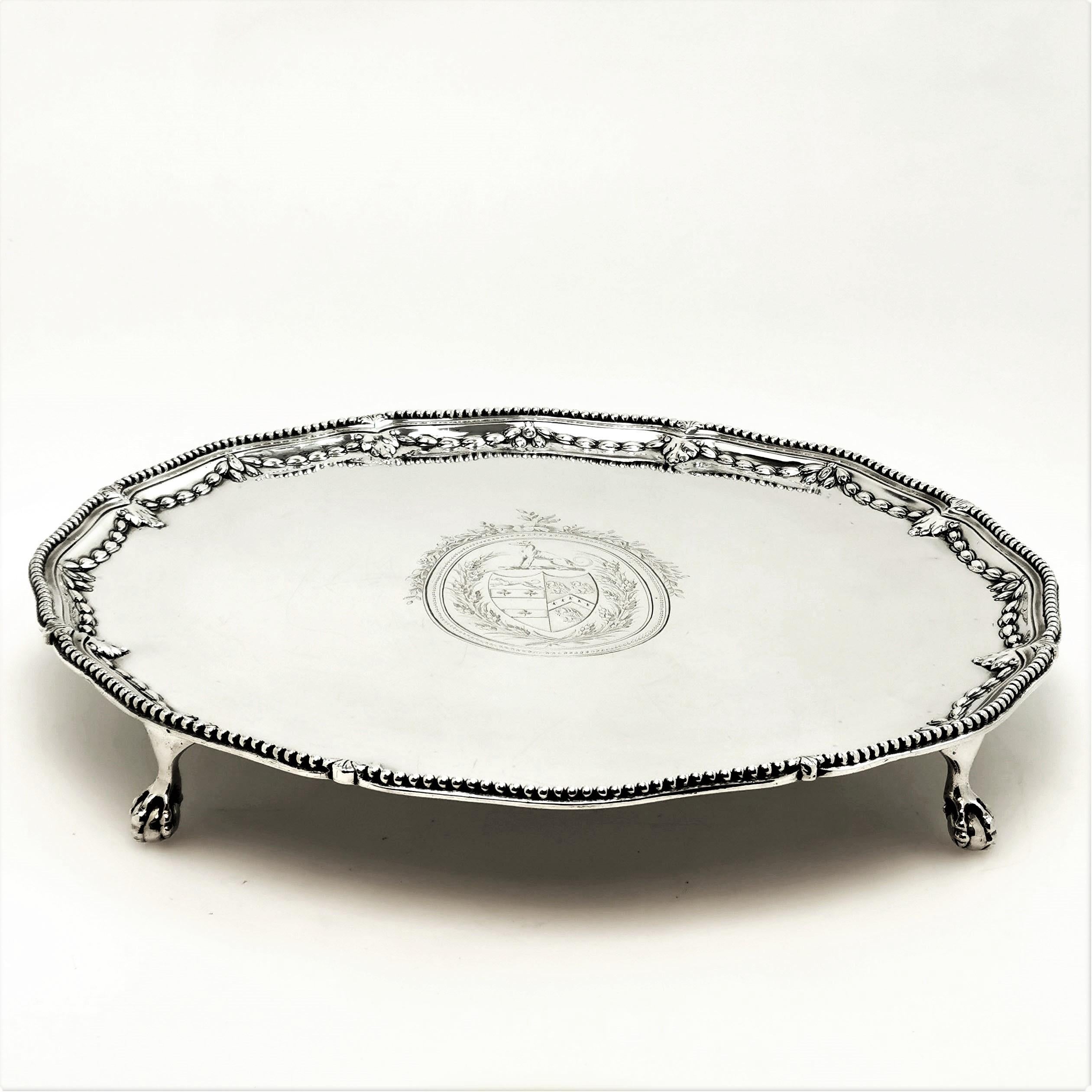 A beautiful antique Georgian round Silver Salver with a shaped beaded edge. The Salver is embellished with a chased wreath edge directly on the inside of the beaded rim. The Salver features an impressive engraved crest in the centre. The Salver
