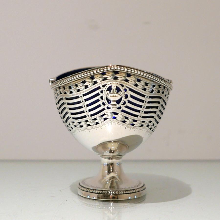 A beautiful bright cut engraved swing handle oval bead decorated sterling silver sugar basket sitting on a raised pedestal foot and presented with a blue inner glass liner for decorative contrast.

Weight: 11 troy ounces/344 grams

Measures: