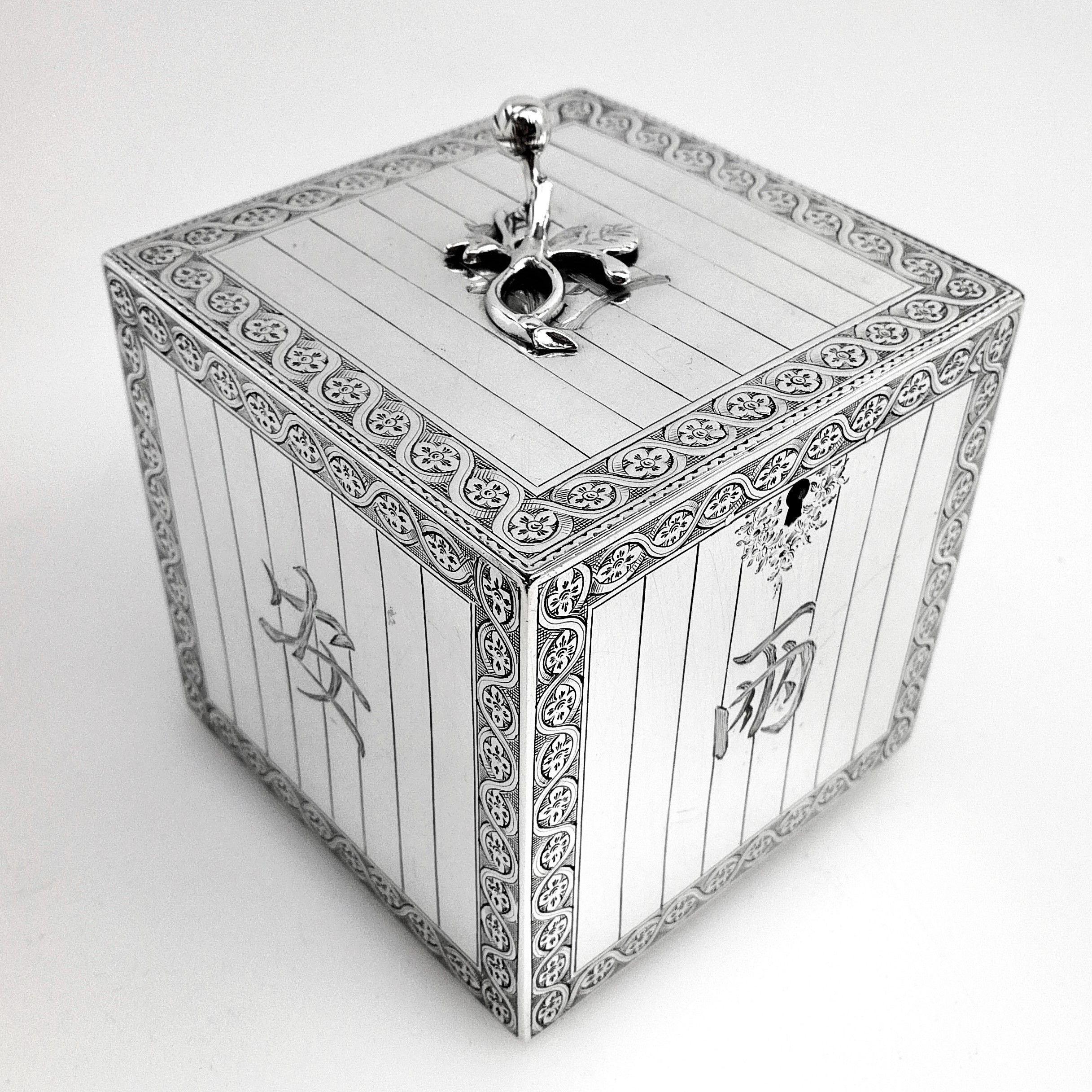 An unusual antique Georgian George III sterling silver tea caddy box in a clean, square form in the style of a traditional Chinese tea chest. Each of the exterior surfaces features an engraved silver border surrounding stylized 'plank' designs. Each