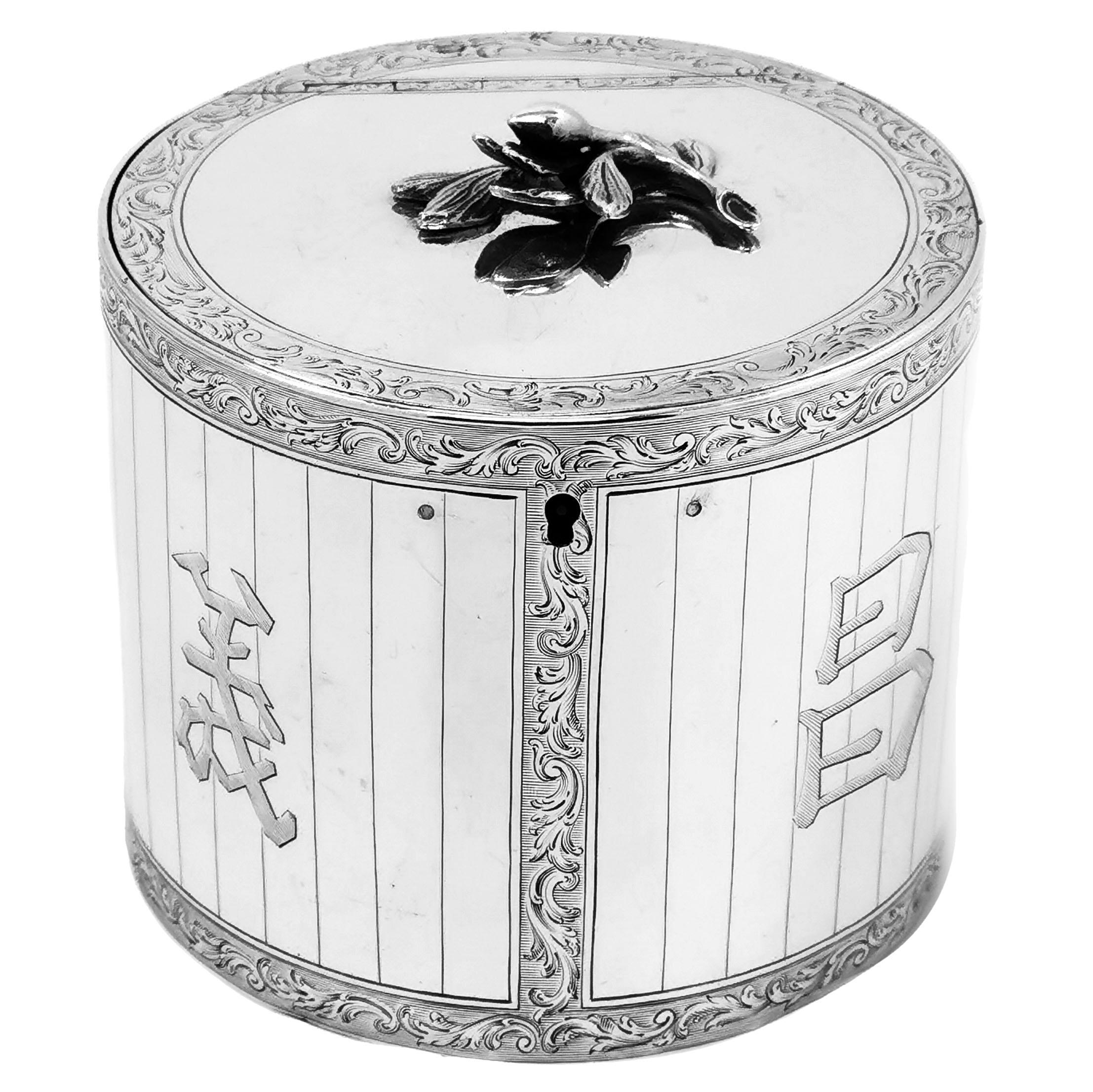A beautiful Antique George III solid Silver Tea Caddy in a traditional circular straight sided can shaped form and is decorated with beautiful and detailed engravings. These engravings form ornate scroll borders which create panels on the side of