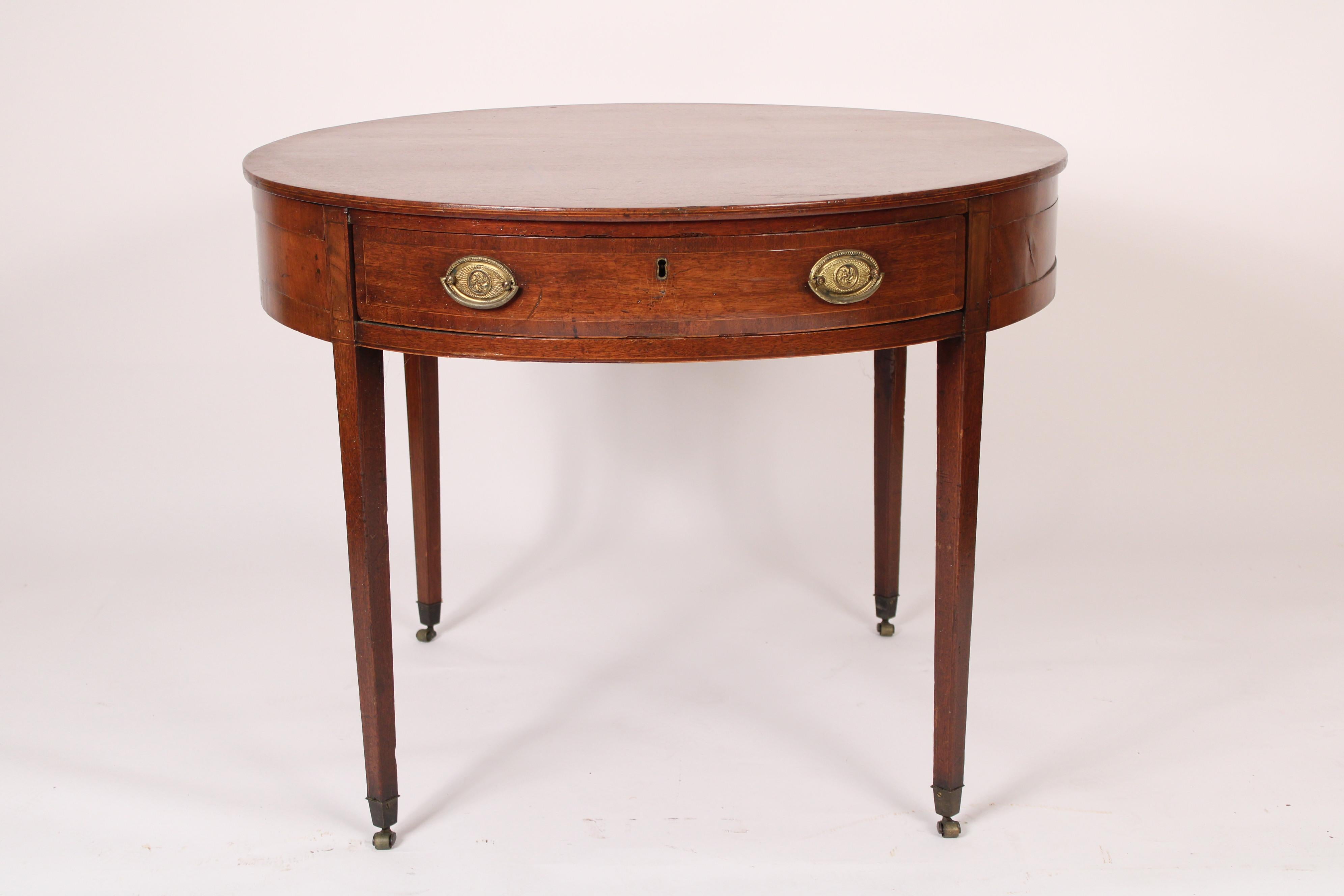 Antique George III style mahogany games / center / side table, 19th century. With a circular top, a frieze with one drawer with brass hardware, resting on square tapered legs ending in brass casters. Hand dove tailed drawer construction.