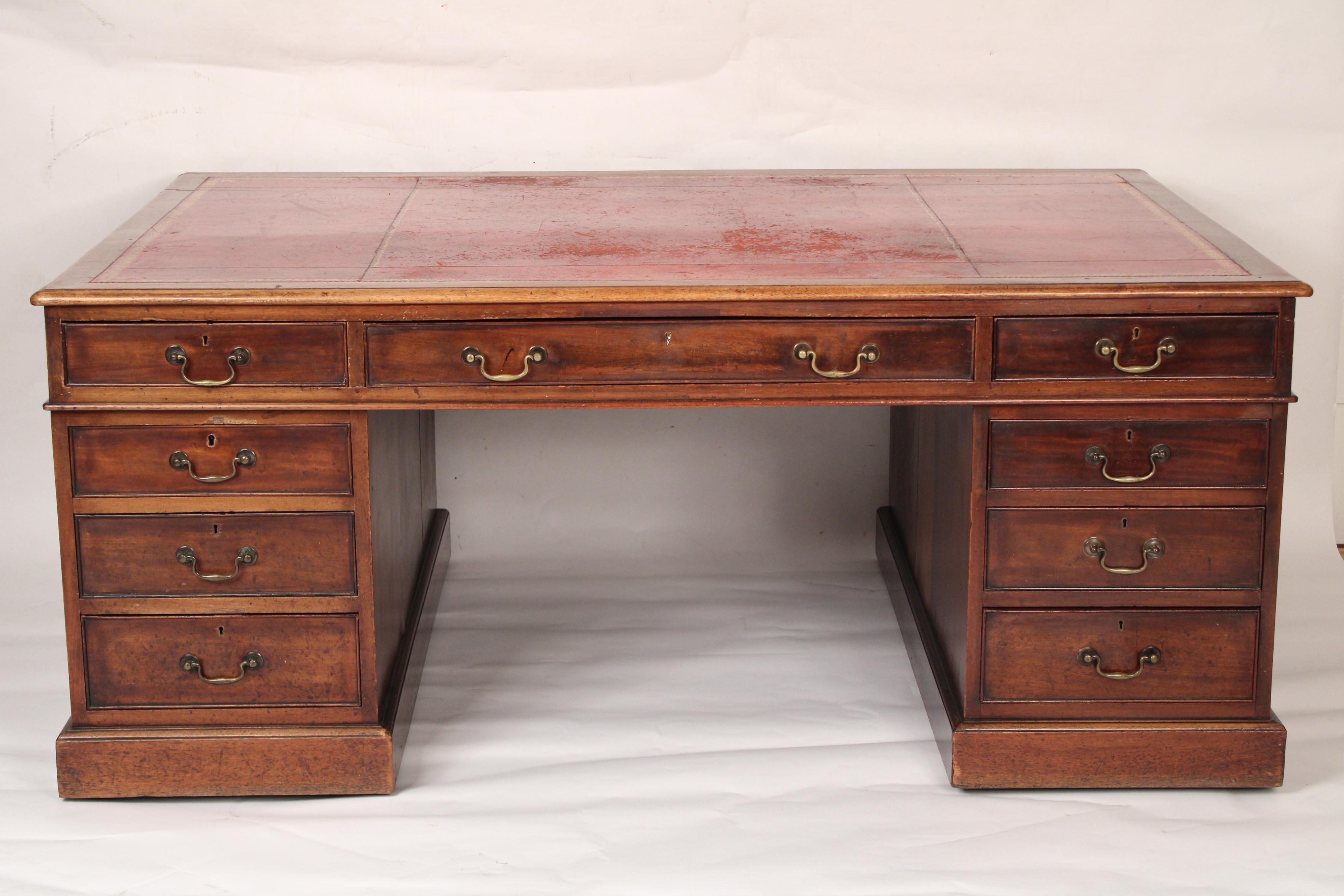 Antique George III style mahogany double pedestal partners desk with a tooled leather top, 19th century. Having a mahogany rectangular top inset with red tooled leather. The front of the desk with 3 frieze drawers over two pedestals each with three