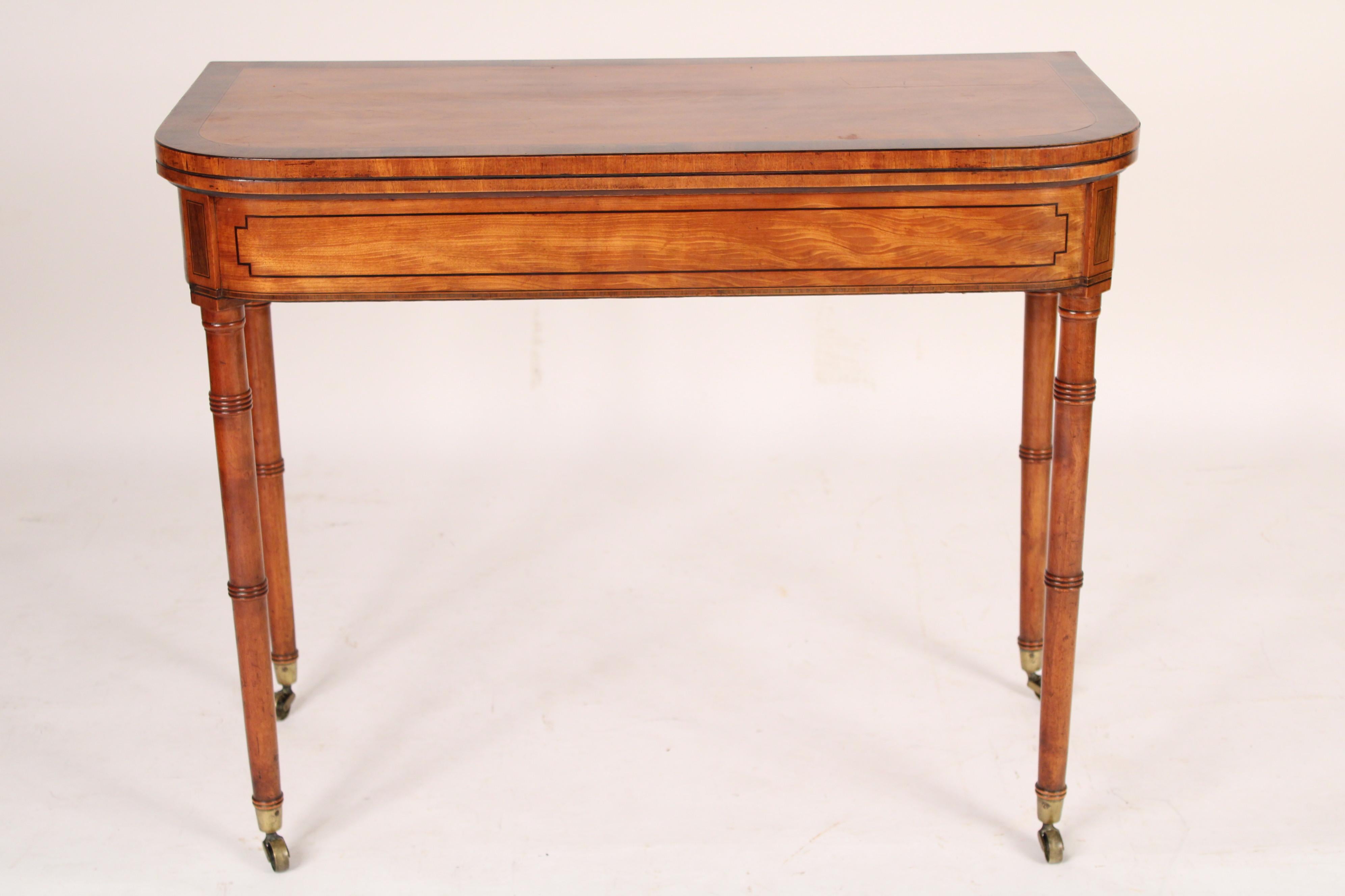 Antique George III style satin wood and rose wood D shaped console games table, 19th century. With a D shaped satin wood top with rose wood cross banding, a frieze with nicely grained satin wood and line inlay, 4 turned tapered legs with ring