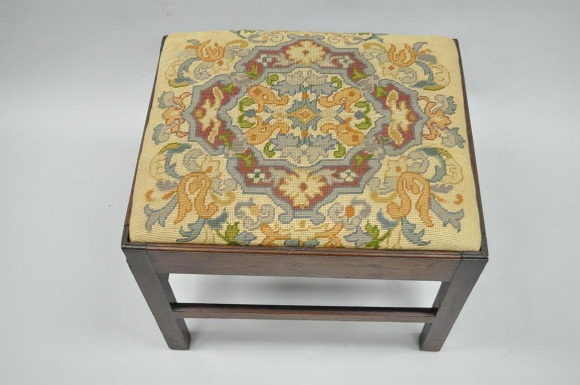 Antique George III English solid mahogany needlepoint bench. Item features solid mahogany stretcher supported base, square section legs, beautiful needlepoint upholstered seat, circa early 19th century. Measurements: 19