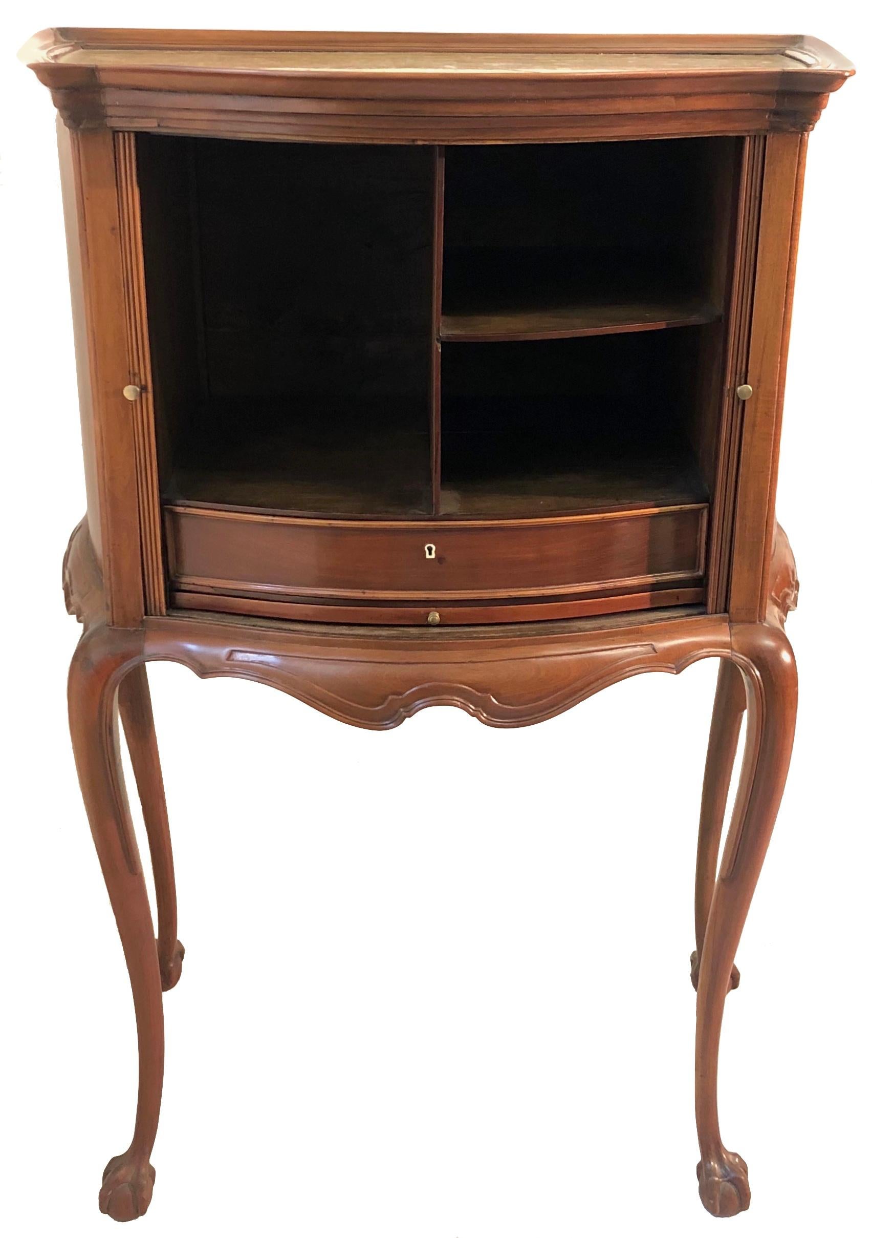 This charming writing and reading cabinet is made out of mahogany and oak. The top is covered by a warm yellow marble board fixated by an undulated mahogany frame. Two sliding doors reveal a drawer, storage space and a shelf for documents and