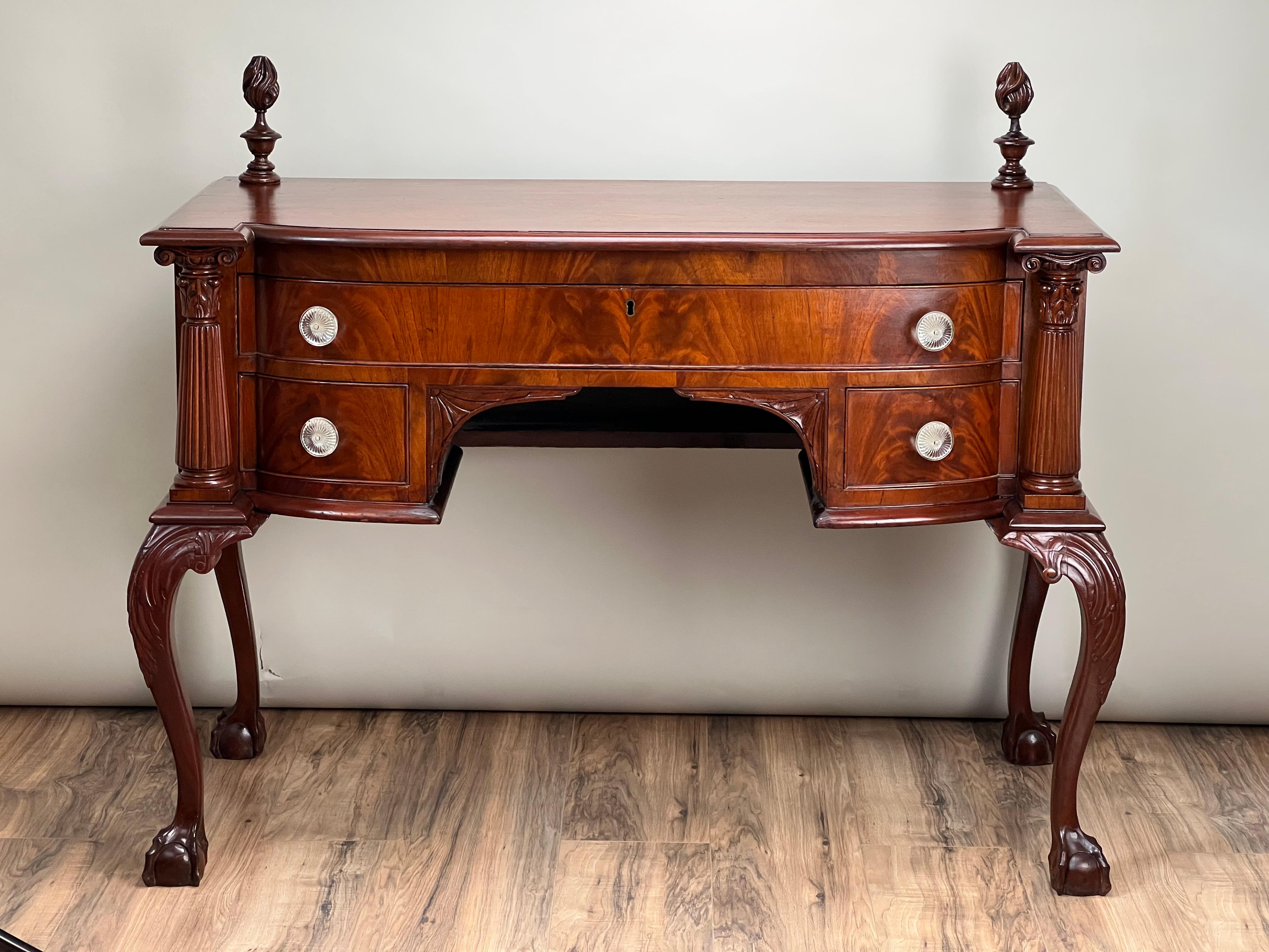 Questo antico buffet in mogano a fiamma Chippendale George IV, risalente alla metà del XIX secolo, è un bellissimo esempio di artigianato e design raffinato. Realizzato in mogano a fiamma viva, il buffet presenta un sorprendente motivo di venature
